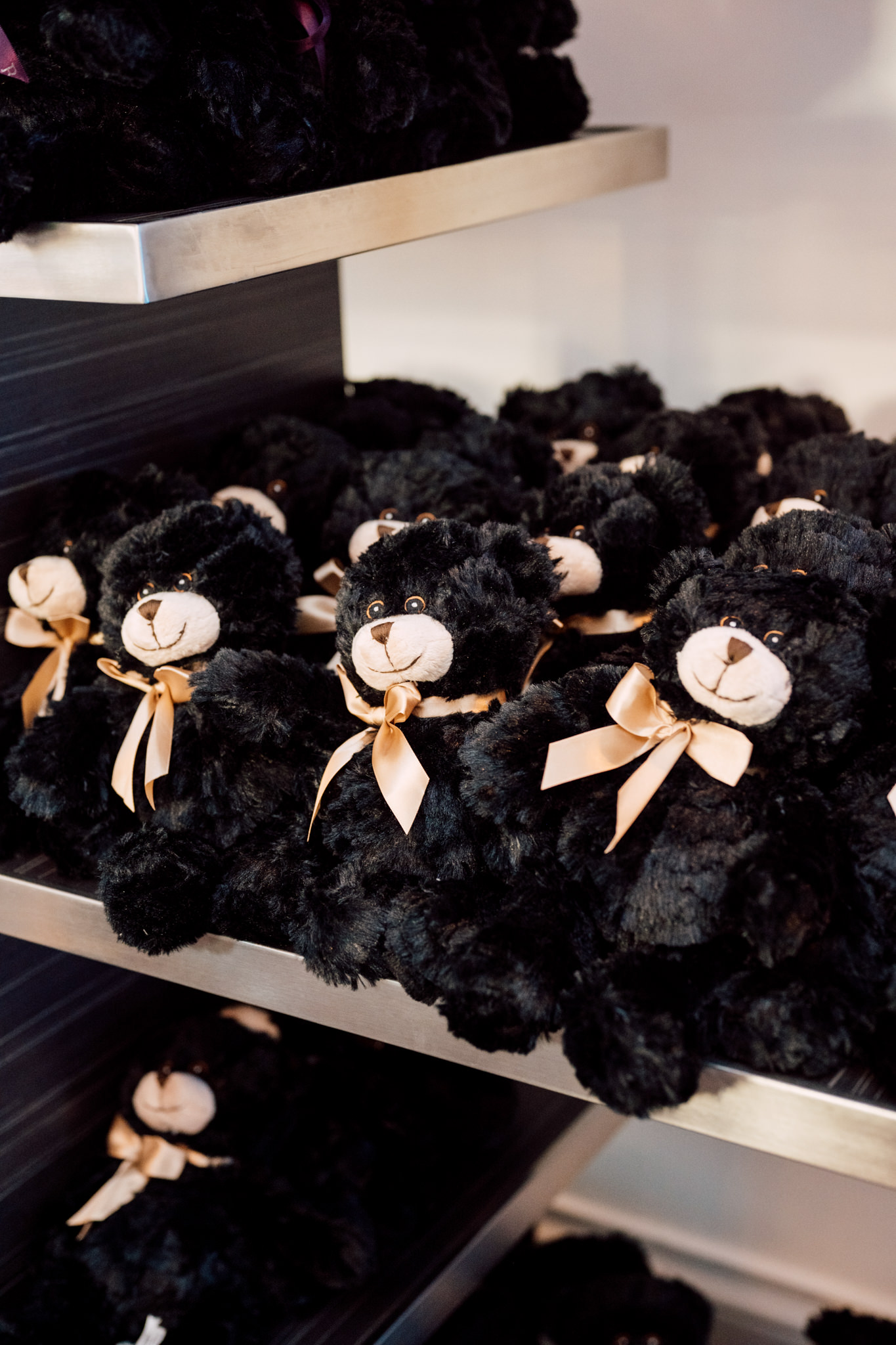A shelf filled with black teddy bears.