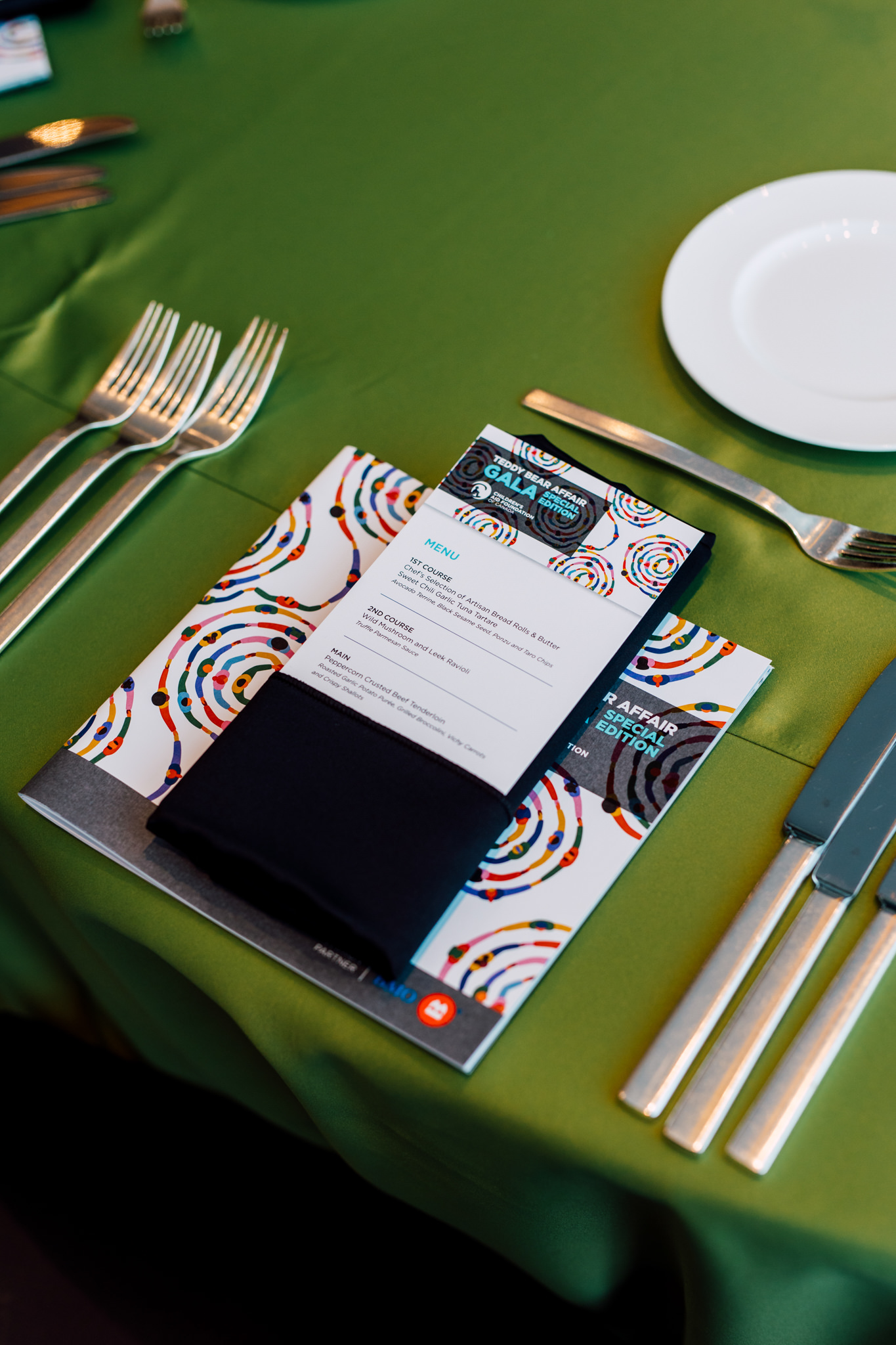 Place setting, green tablecloth.