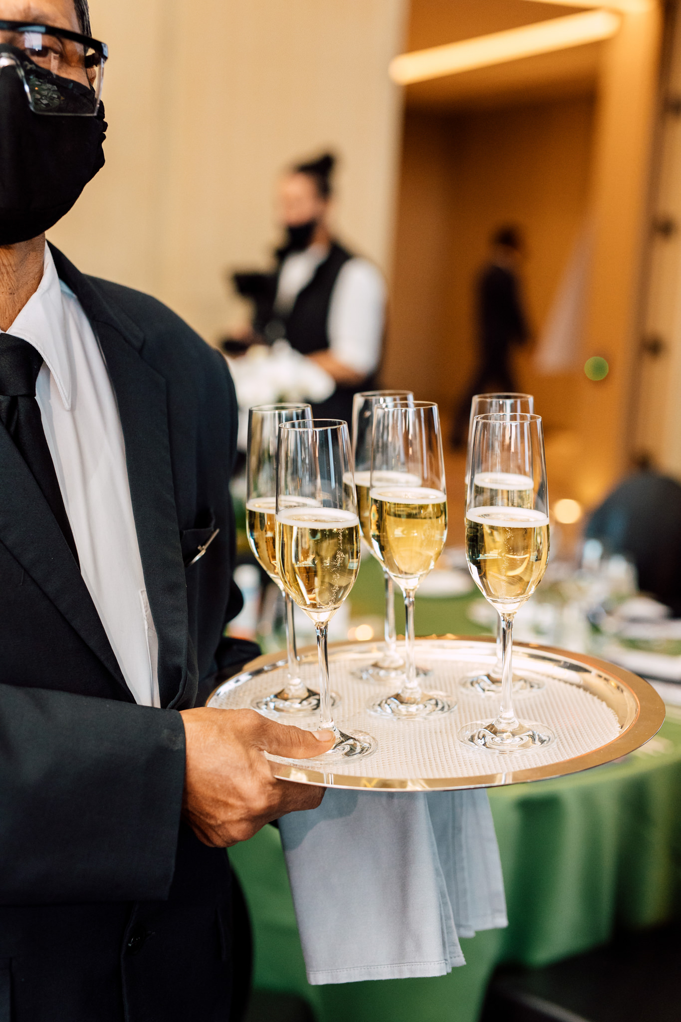 Waiter, tray, champagne glasses.