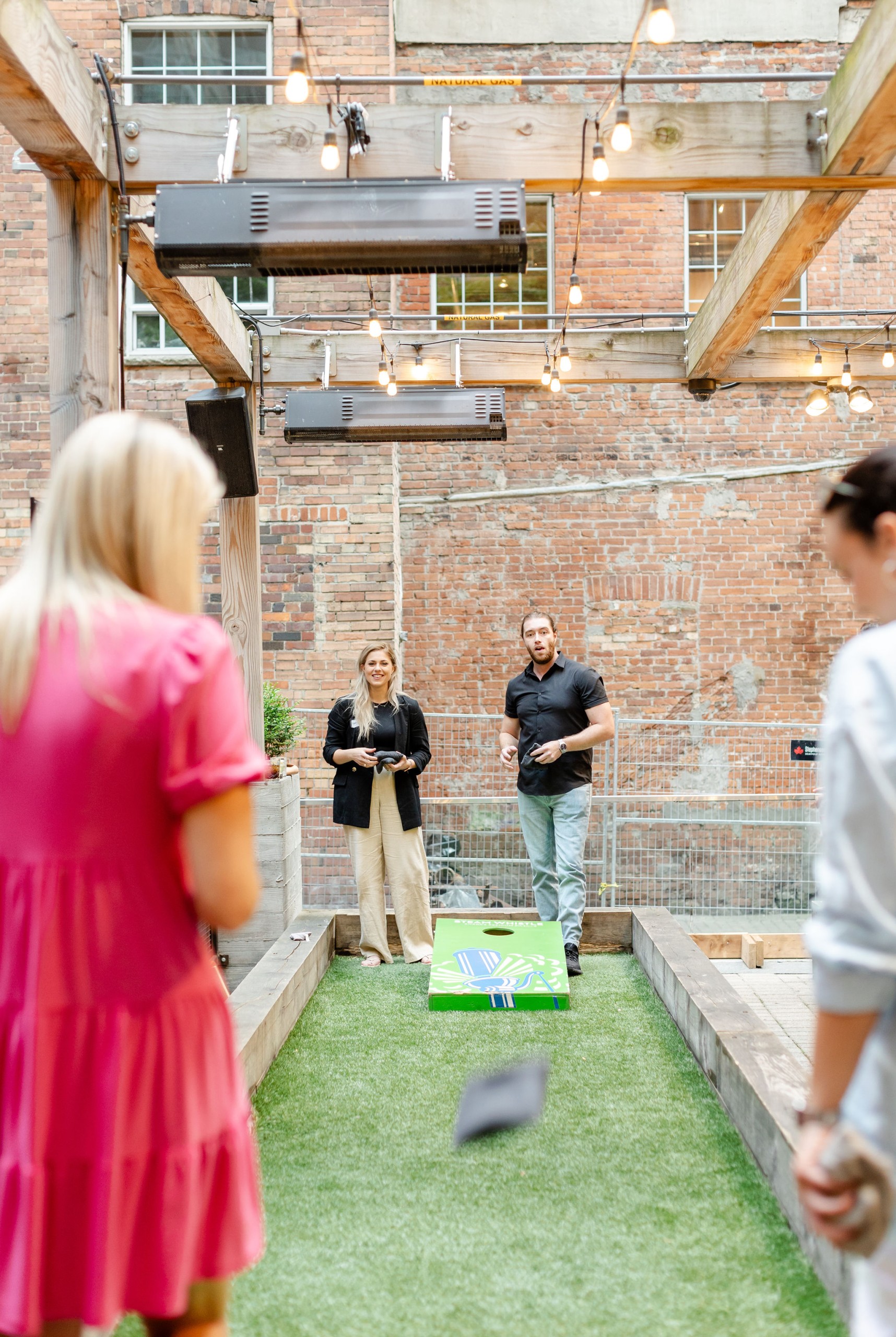 Social event featuring people playing cornhole.