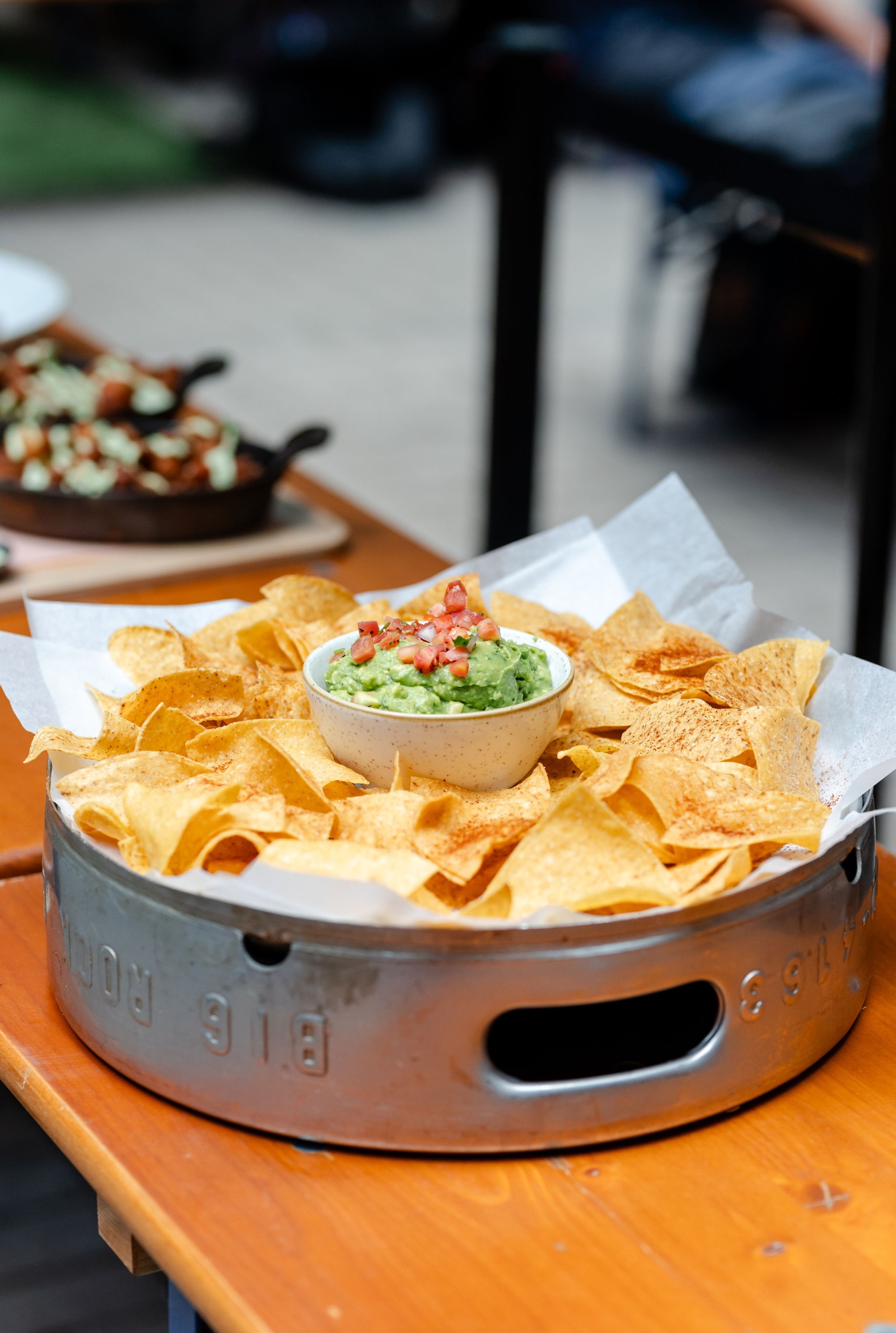 Social event featuring guacamole and chips on a wooden table.