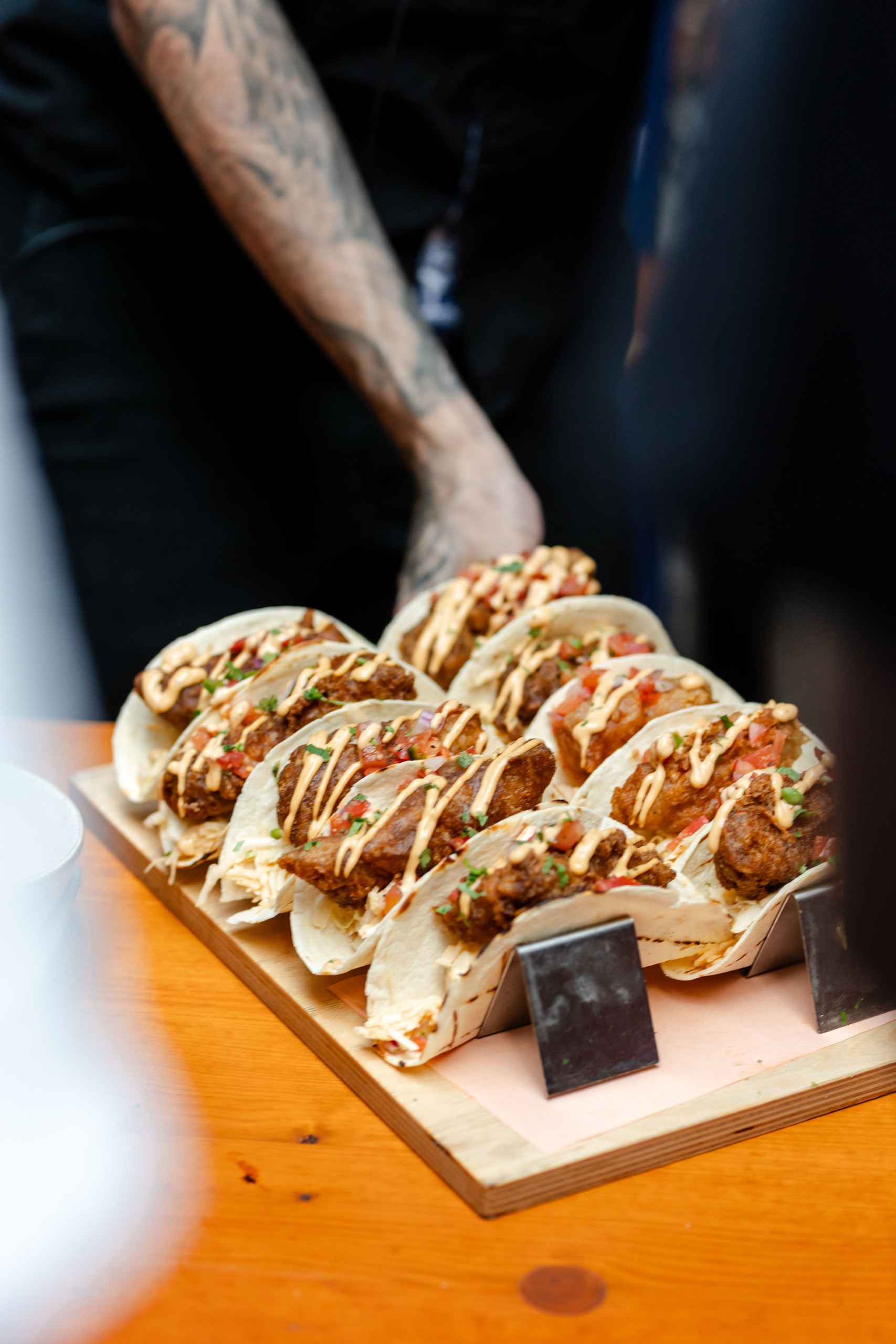 A tray of tacos on a table at a social event.