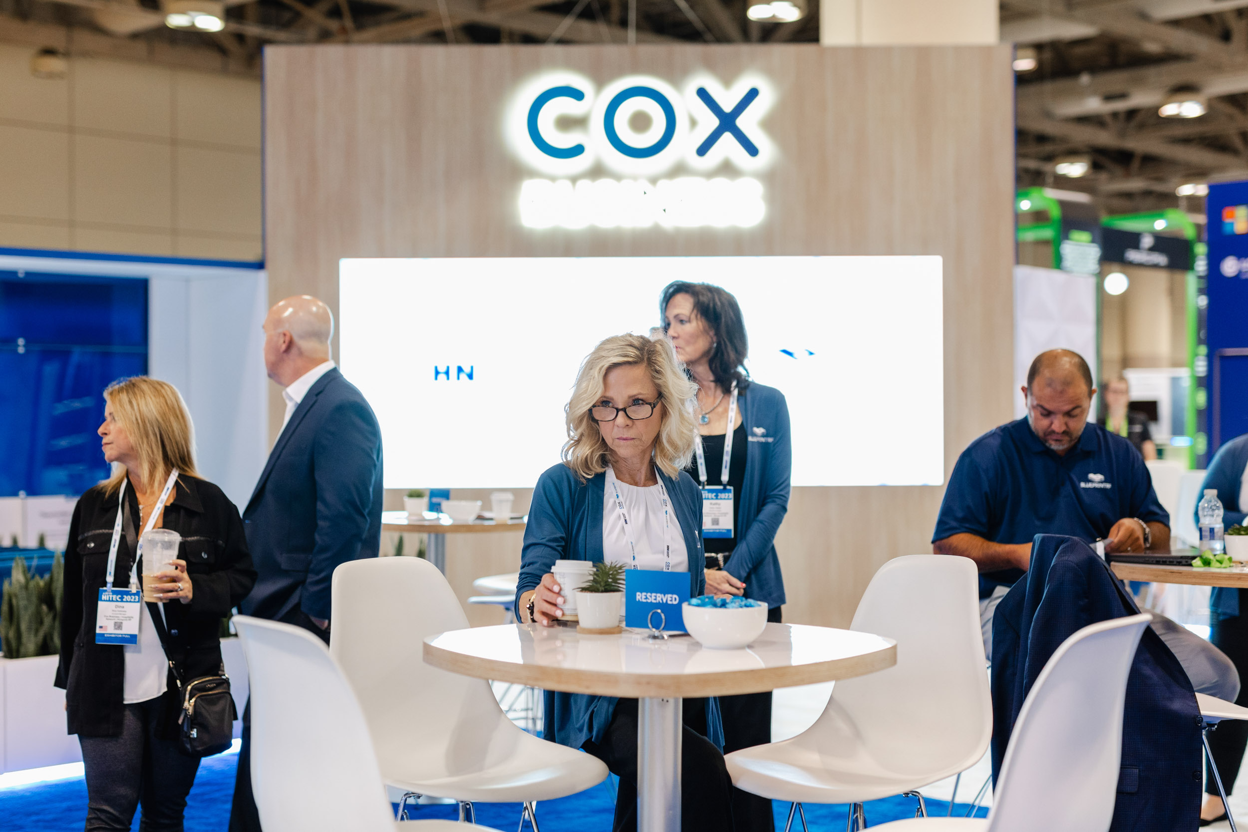 A group of people at a cox business booth captured in Toronto at a trade show through photography.