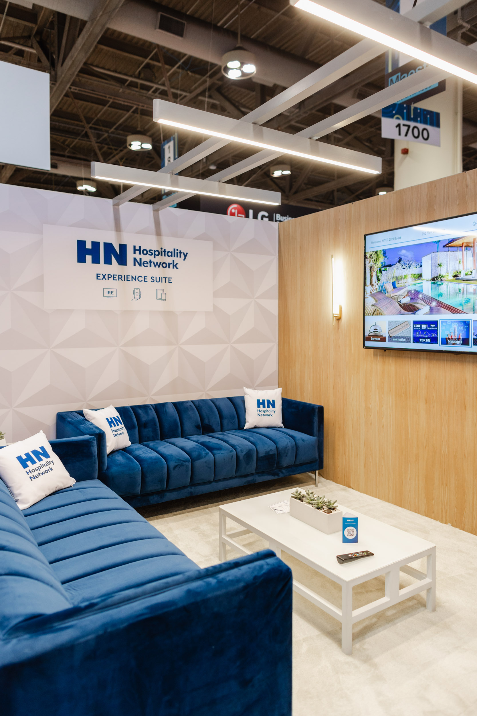 A blue couch in a room with a TV at a Toronto trade show.