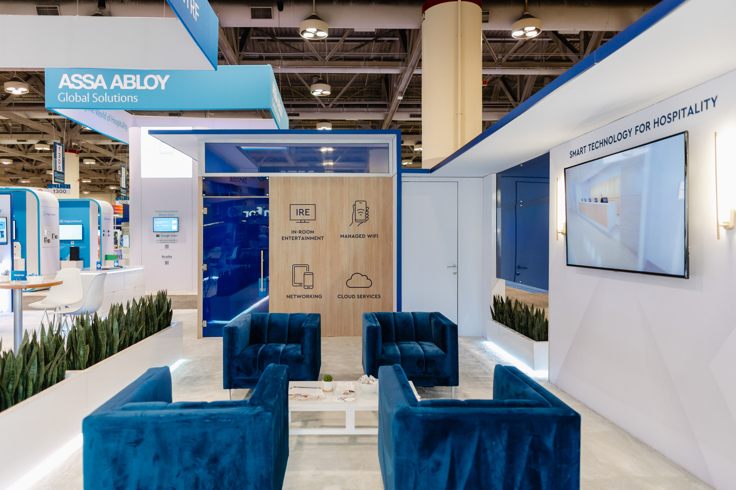 A Toronto trade show booth with blue chairs and a TV.