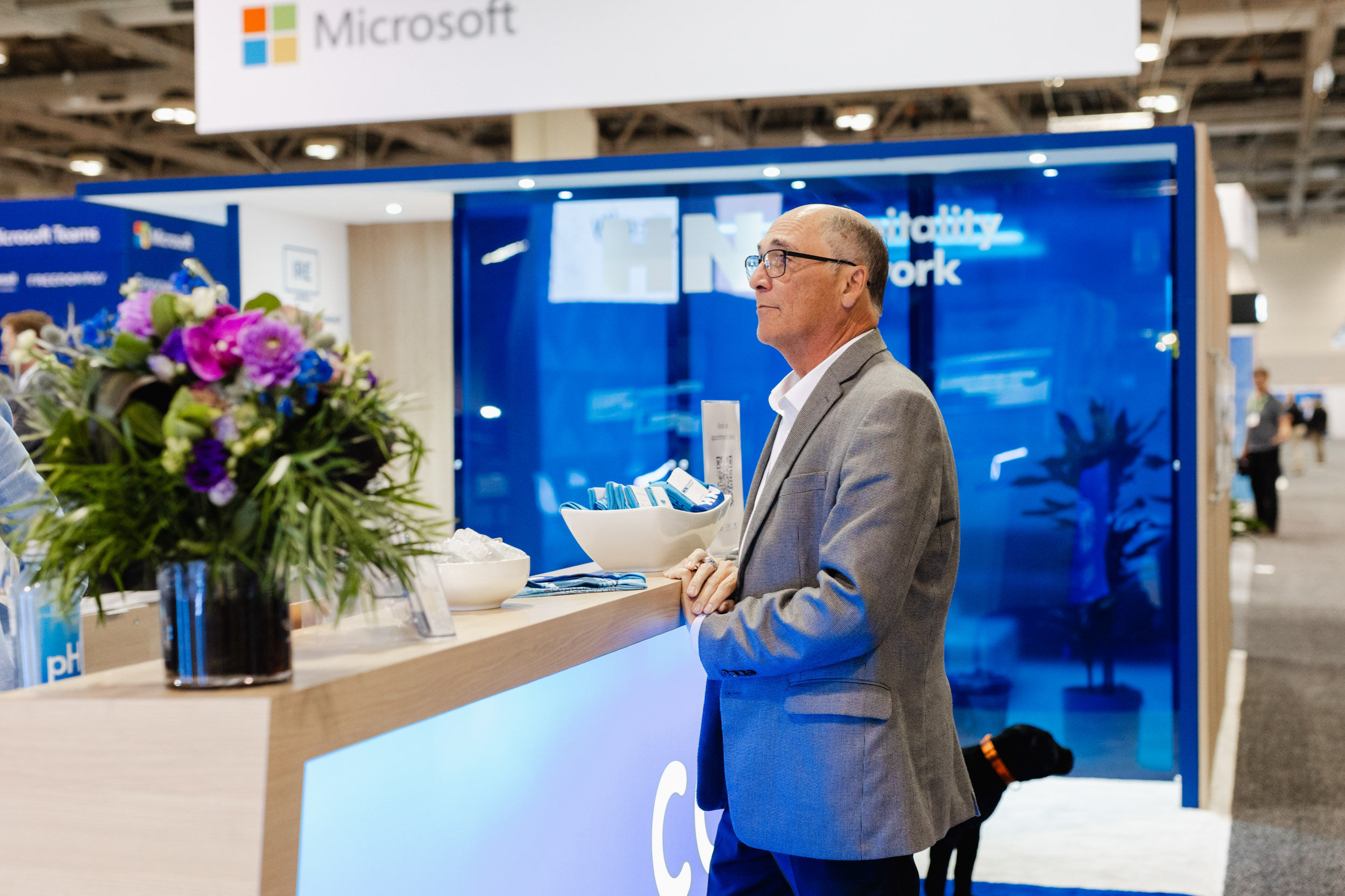 A man photographed at a Toronto trade show in front of a Microsoft booth.