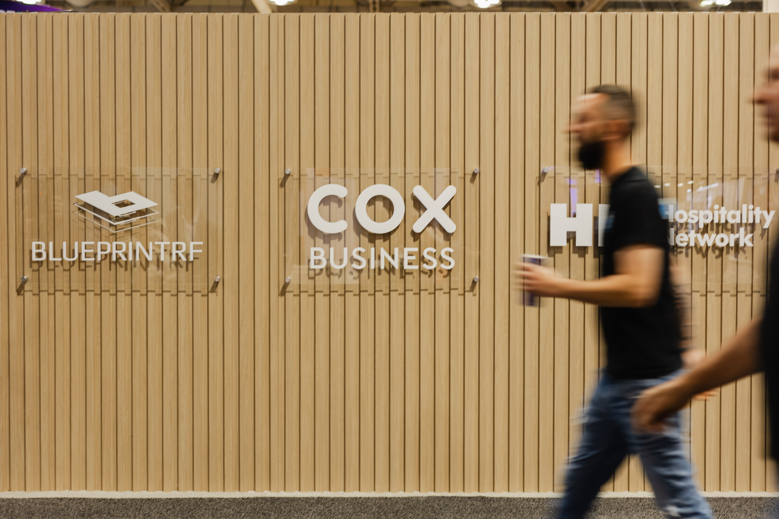 A man walks past a sign that says "Cox Blueprint Business" in Toronto.