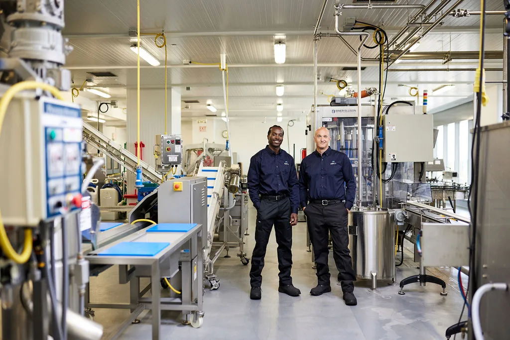 Two men operating a machine in a factory.