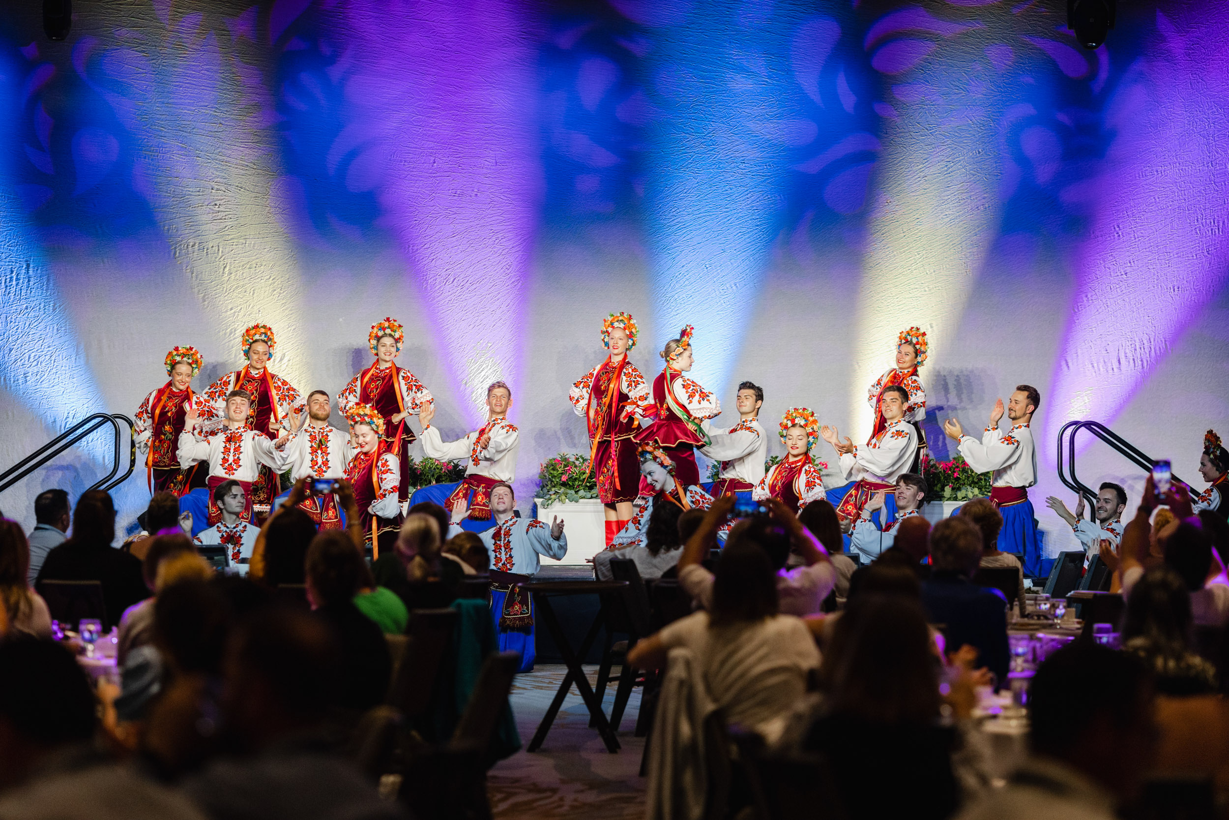 A group of dancers performing onstage at a conference.