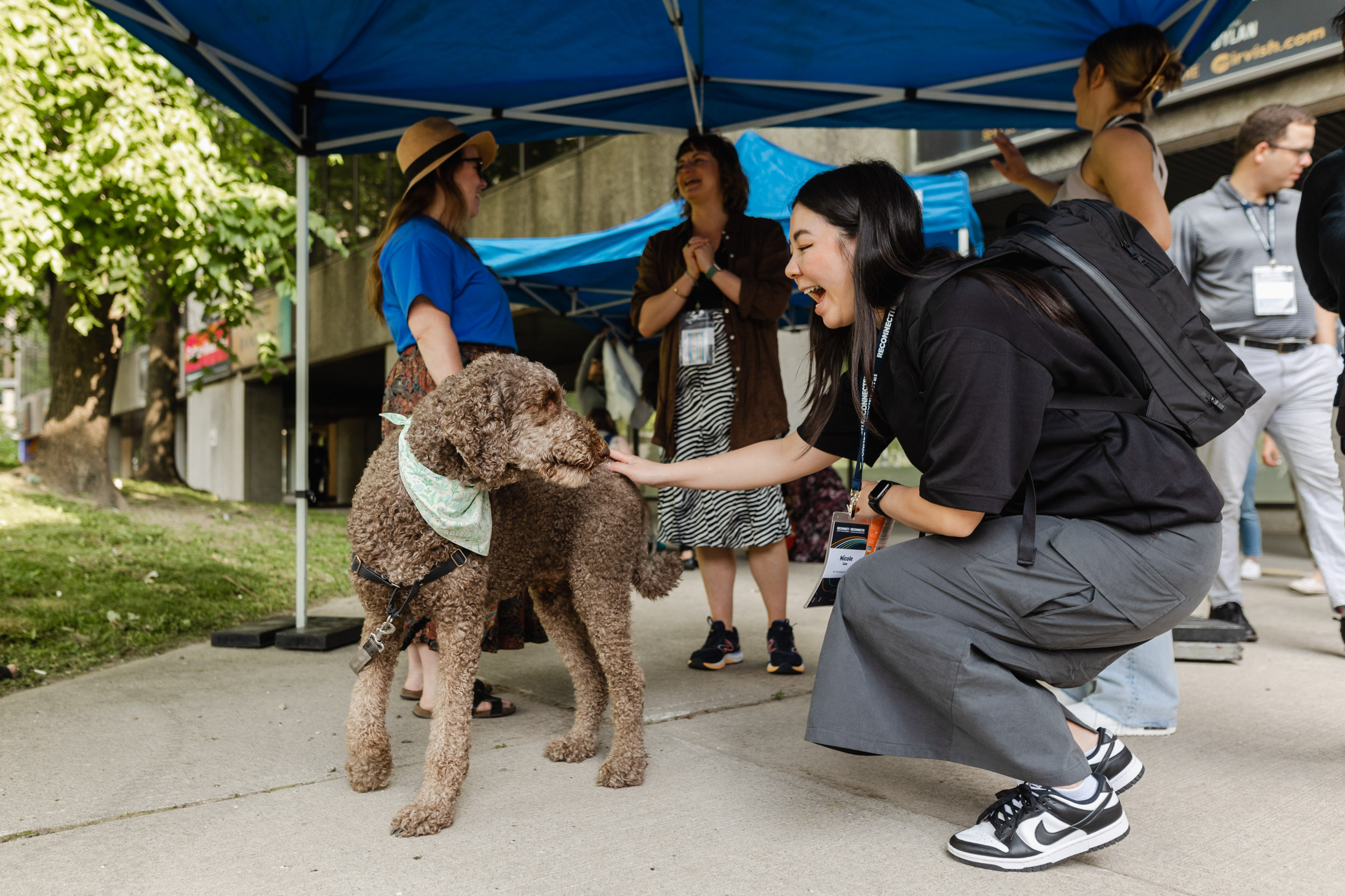 A woman engaging with a dog during conference photography.