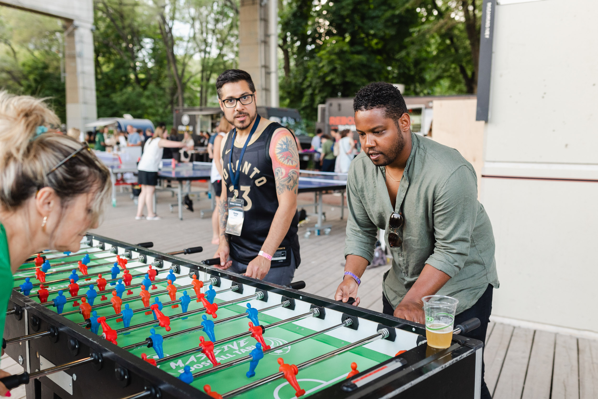 A group of people playing foosball at a conference.