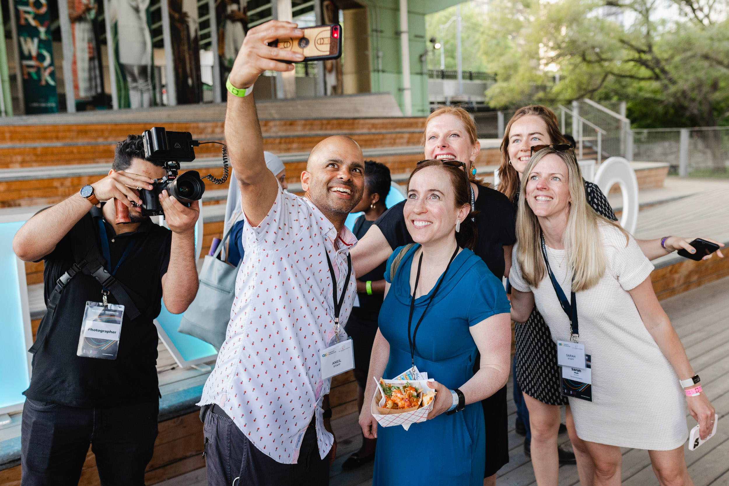 Conference attendees taking a selfie at an outdoor event.