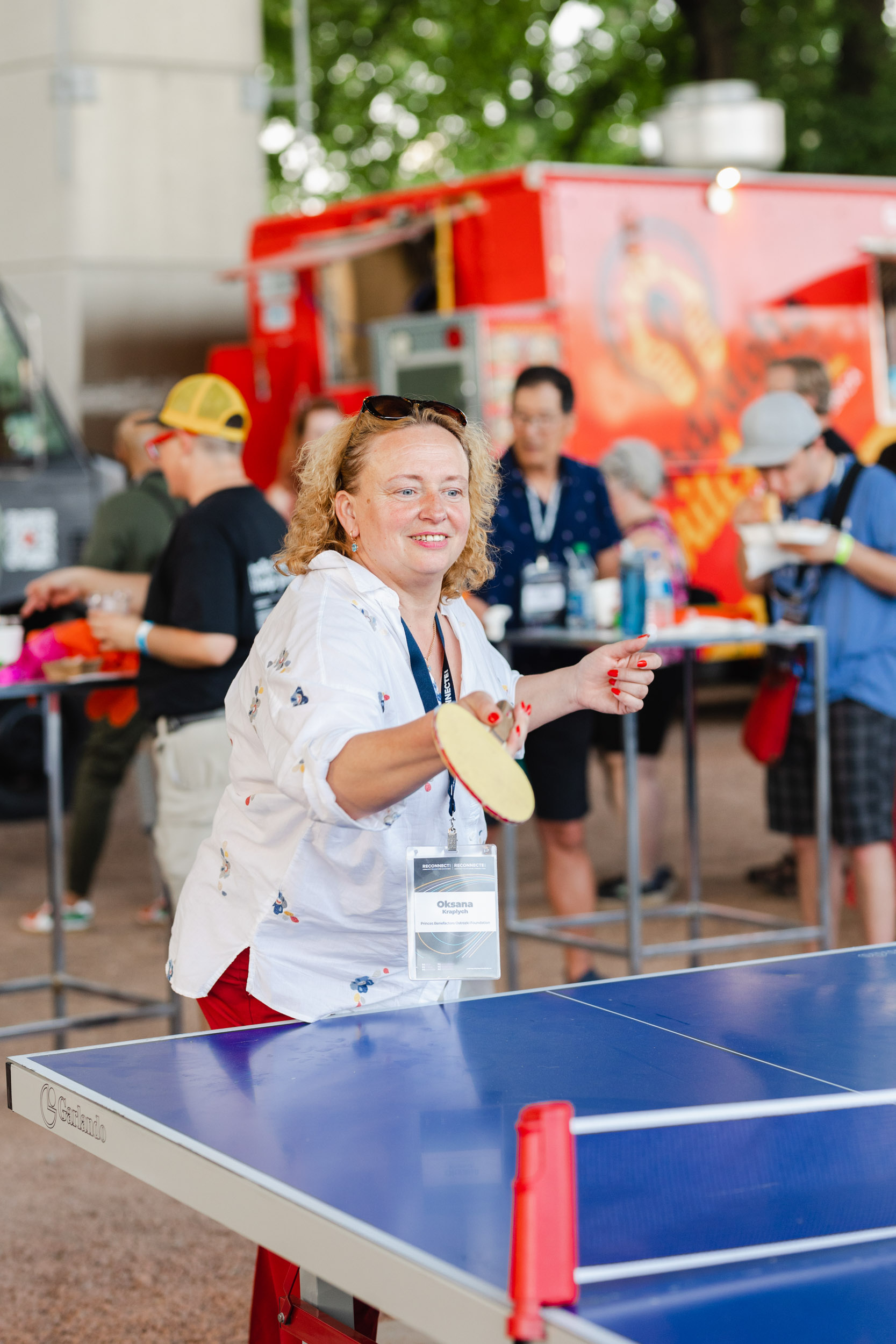 A woman participating in a conference ping pong match.