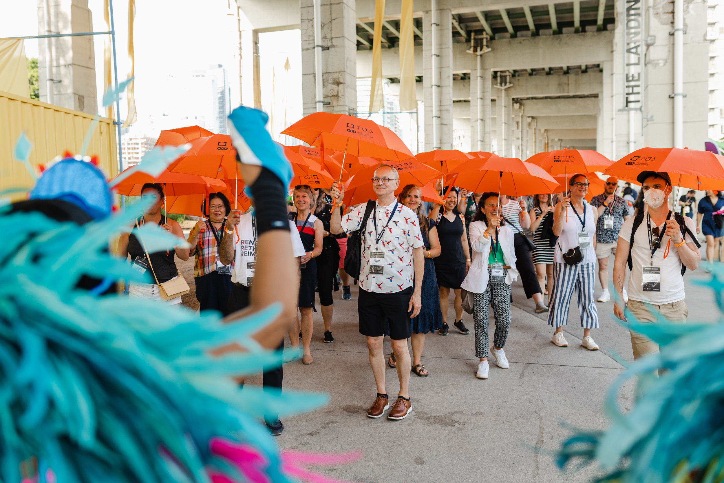 Conference attendees with orange umbrellas.