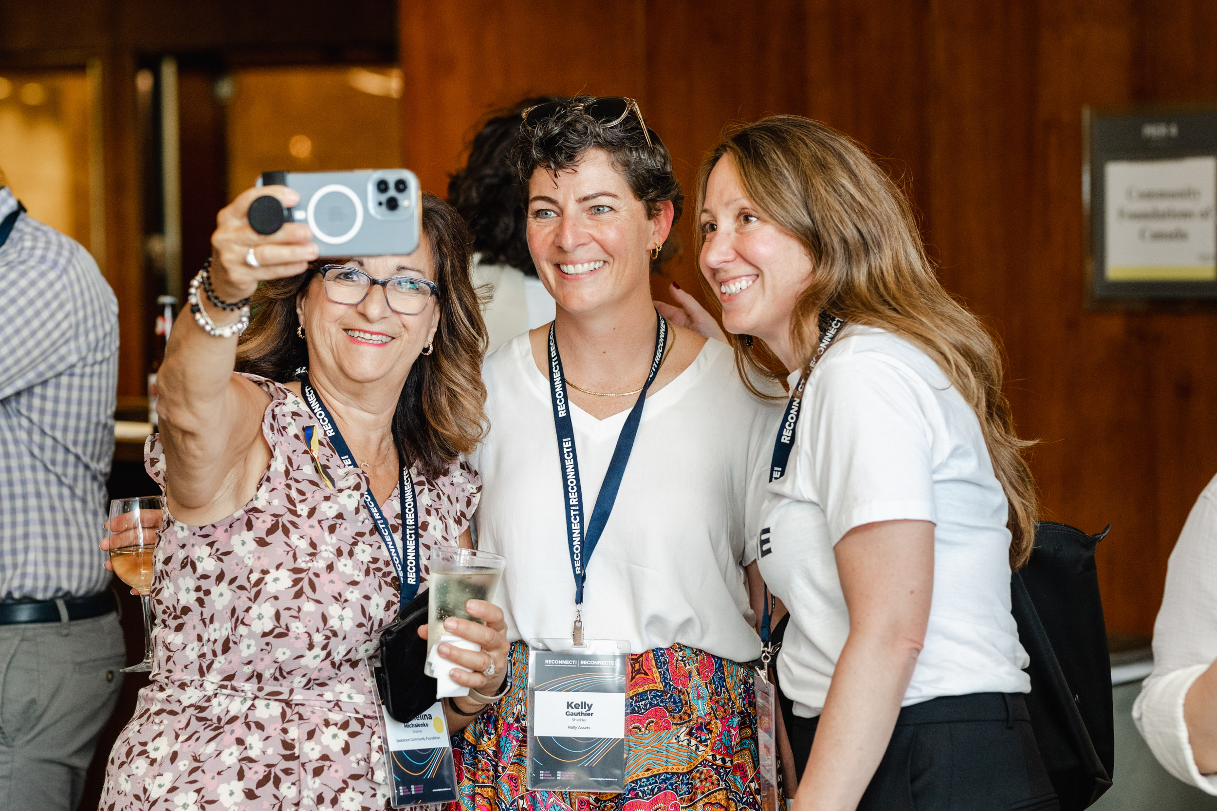 Three women snapping a selfie at a conference.