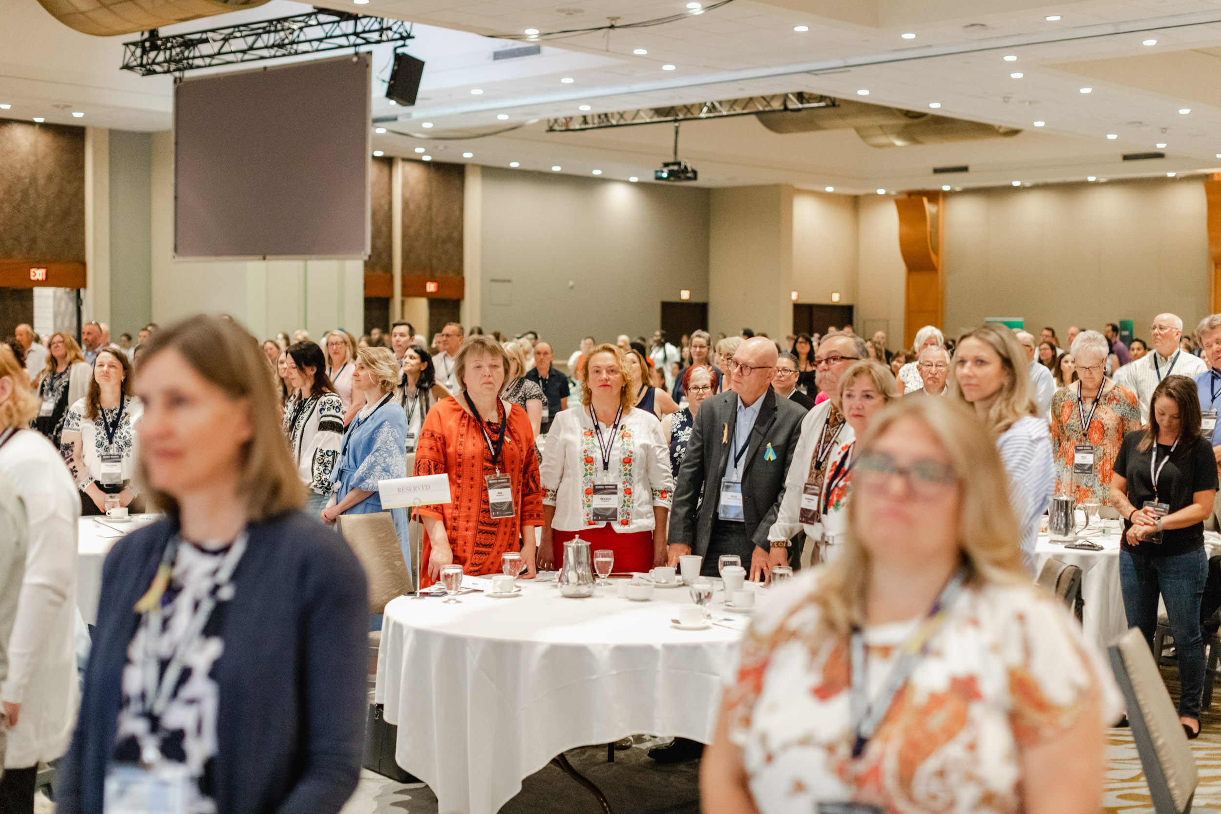 A large group of people gathered for a conference in a room, captured through photography.