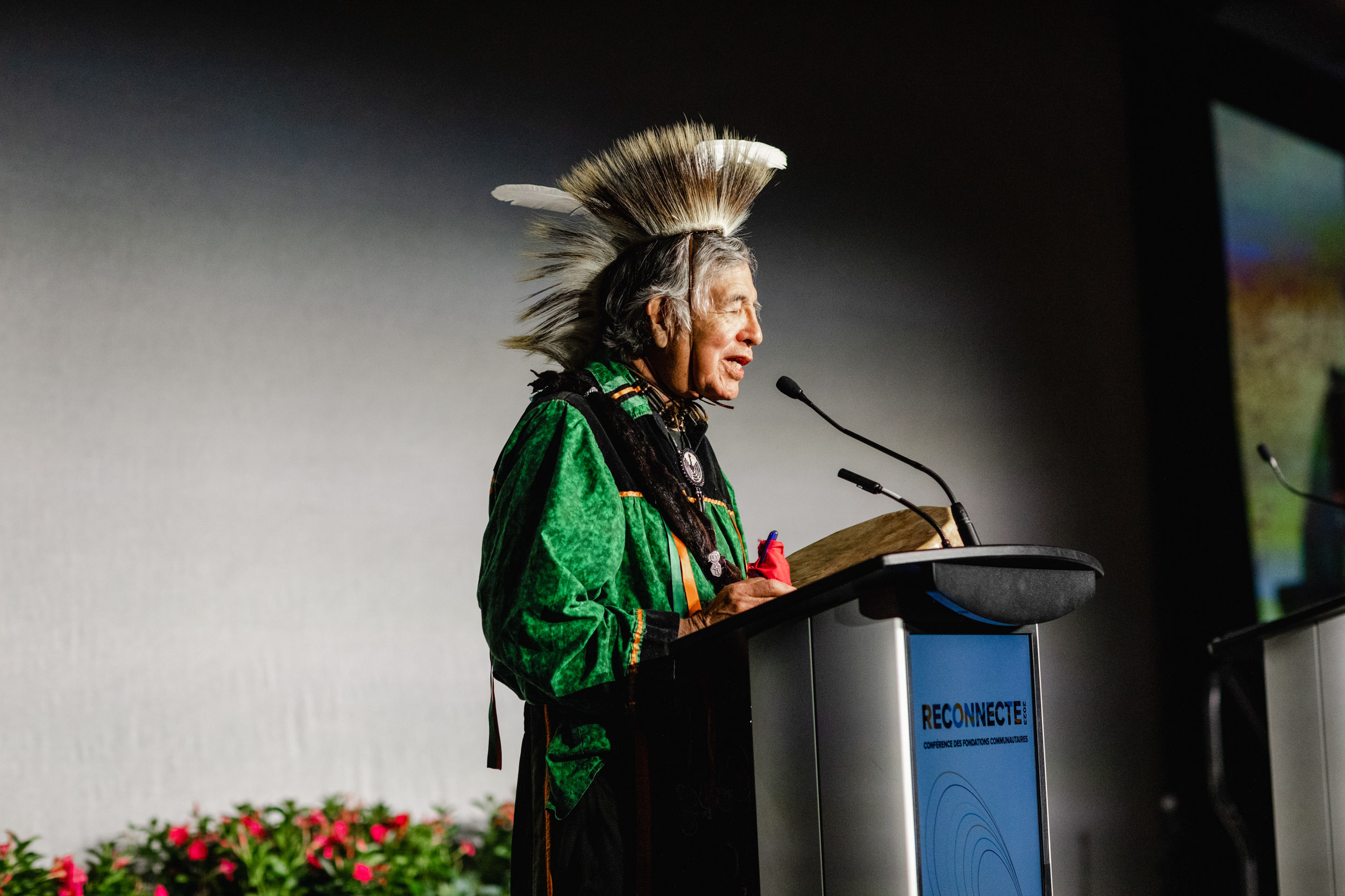 Conference speaker in feathered headdress.