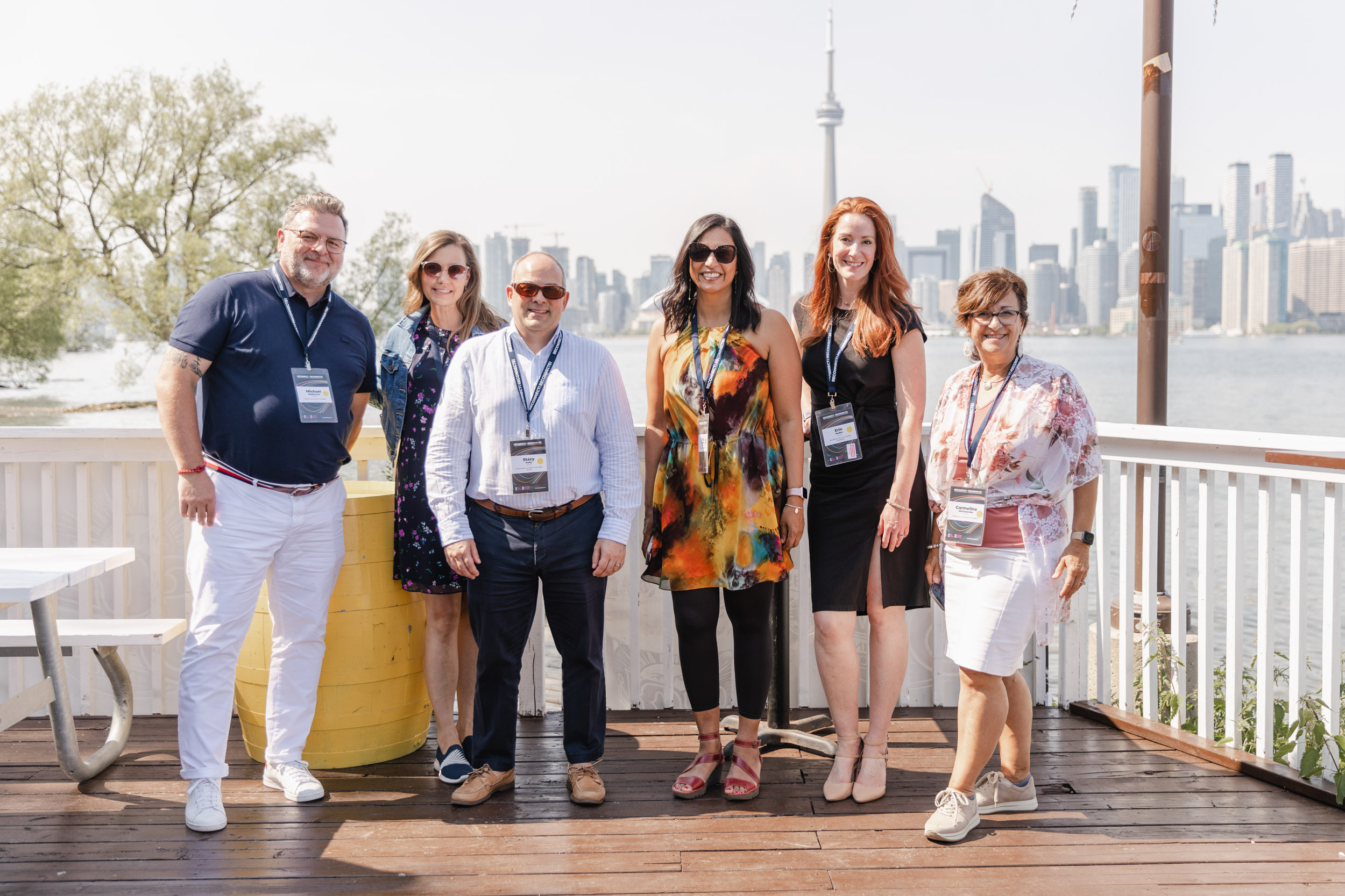 Conference attendees posing on a deck overlooking the city.