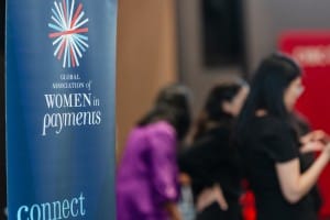 A group of people standing in front of a banner that says women's philanthropy connect captured with grand opening photography.