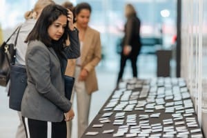 A woman inspecting business cards at a photography-themed grand opening event.