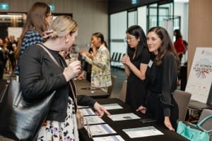 Grand opening event featuring women networking at a table.