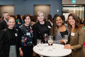 A group of women posing for a photo at a Grand Opening event.