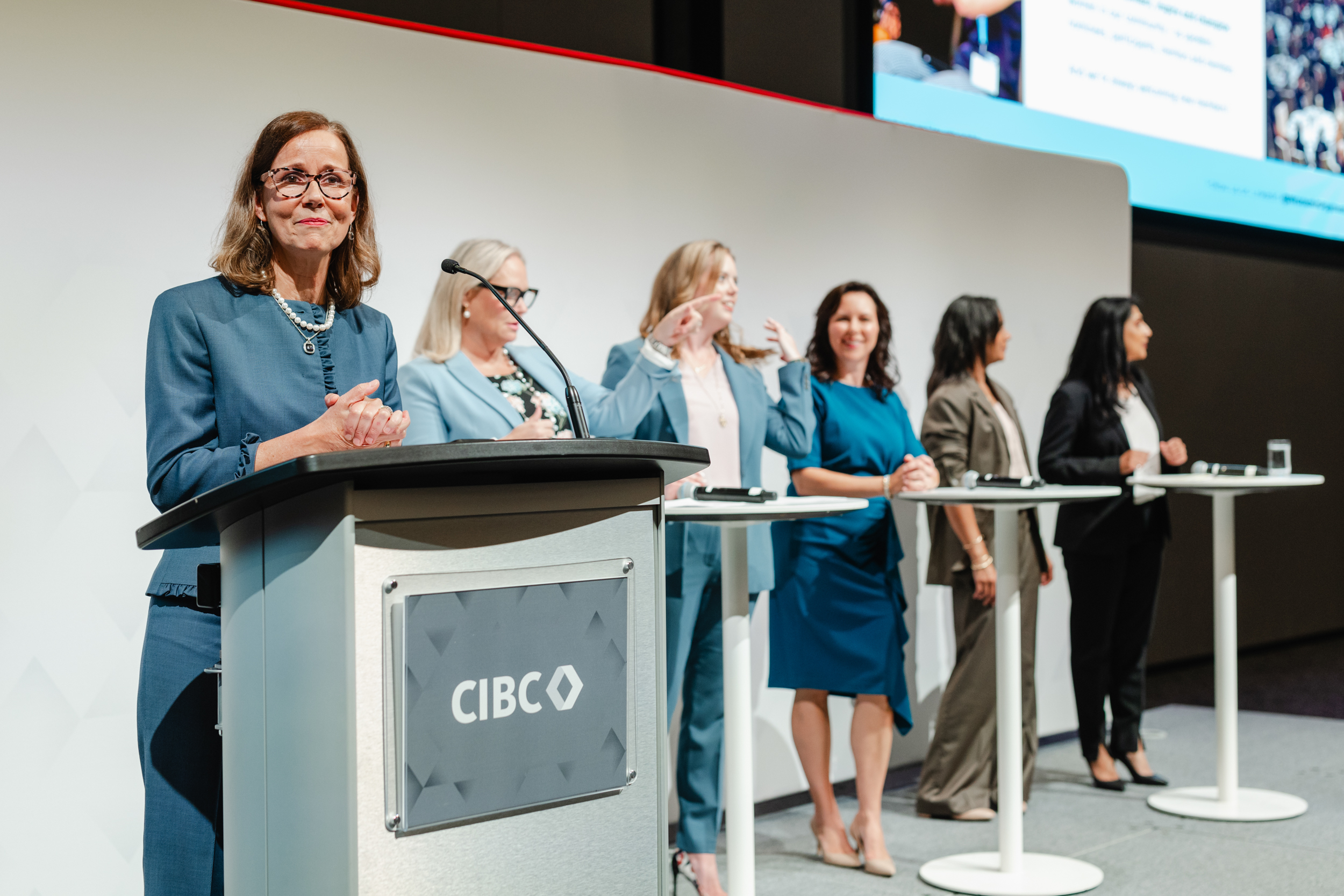 A group of women at a podium captured in grand opening photography.