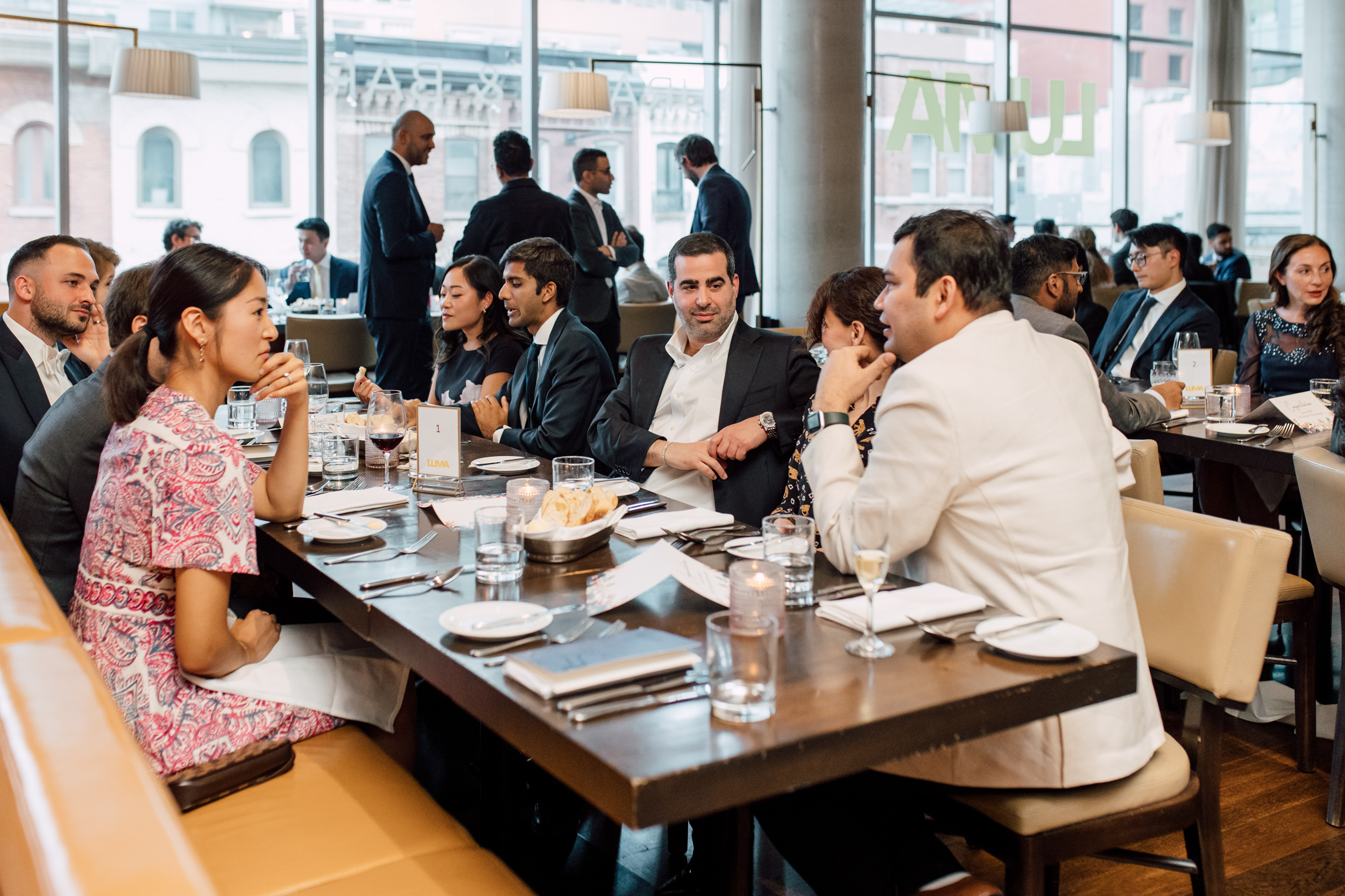 A group of people at a graduation event sitting at a table in a restaurant.