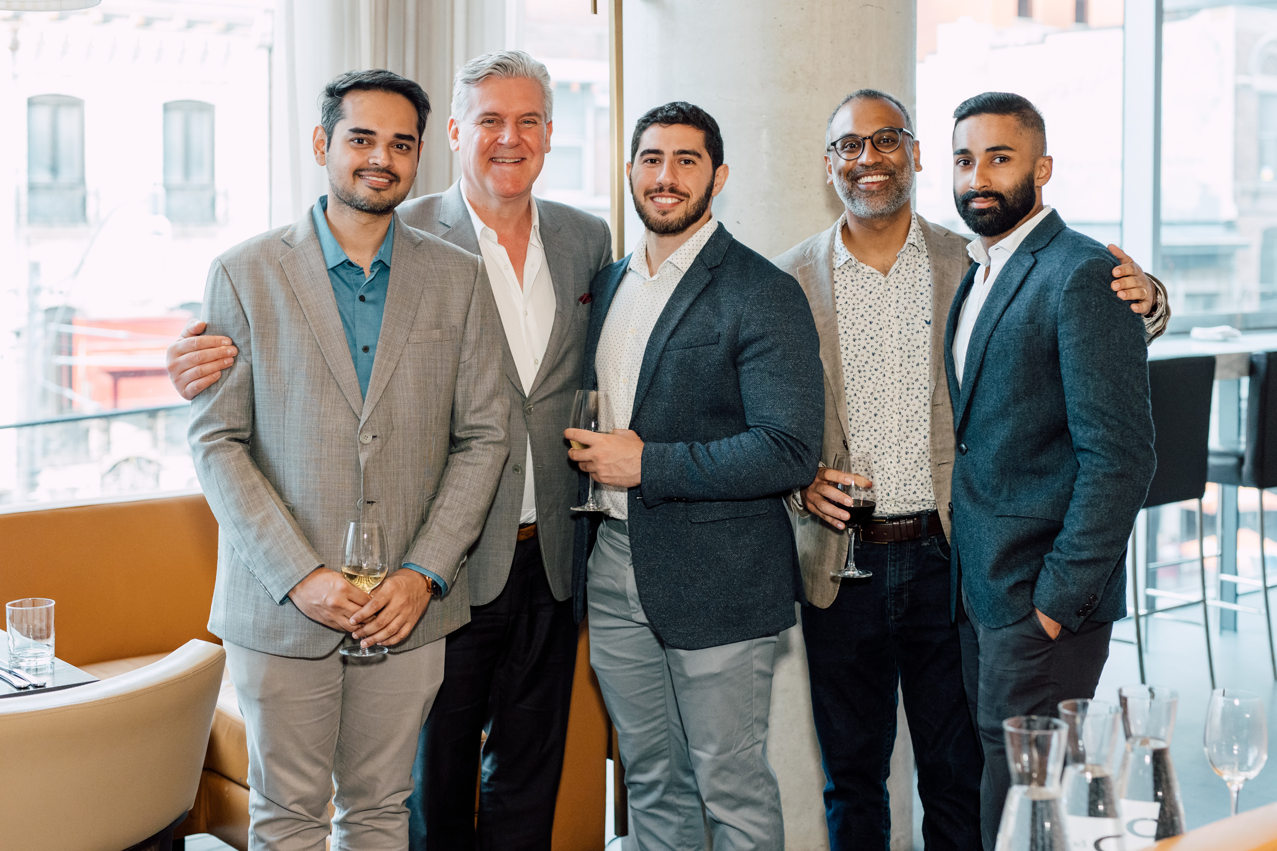 A group of men posing for a graduation event photo in a restaurant.