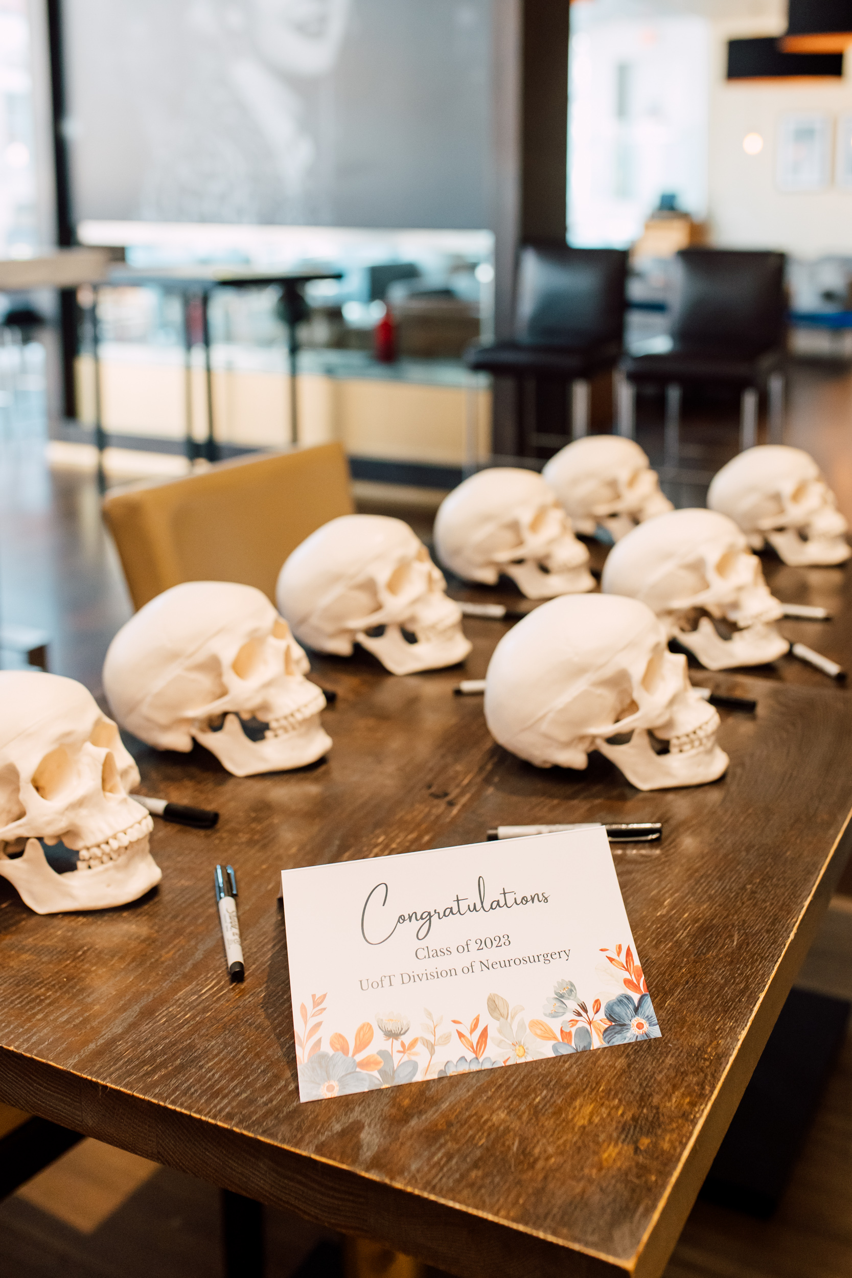A group of graduation skulls on a table with a sign on it.