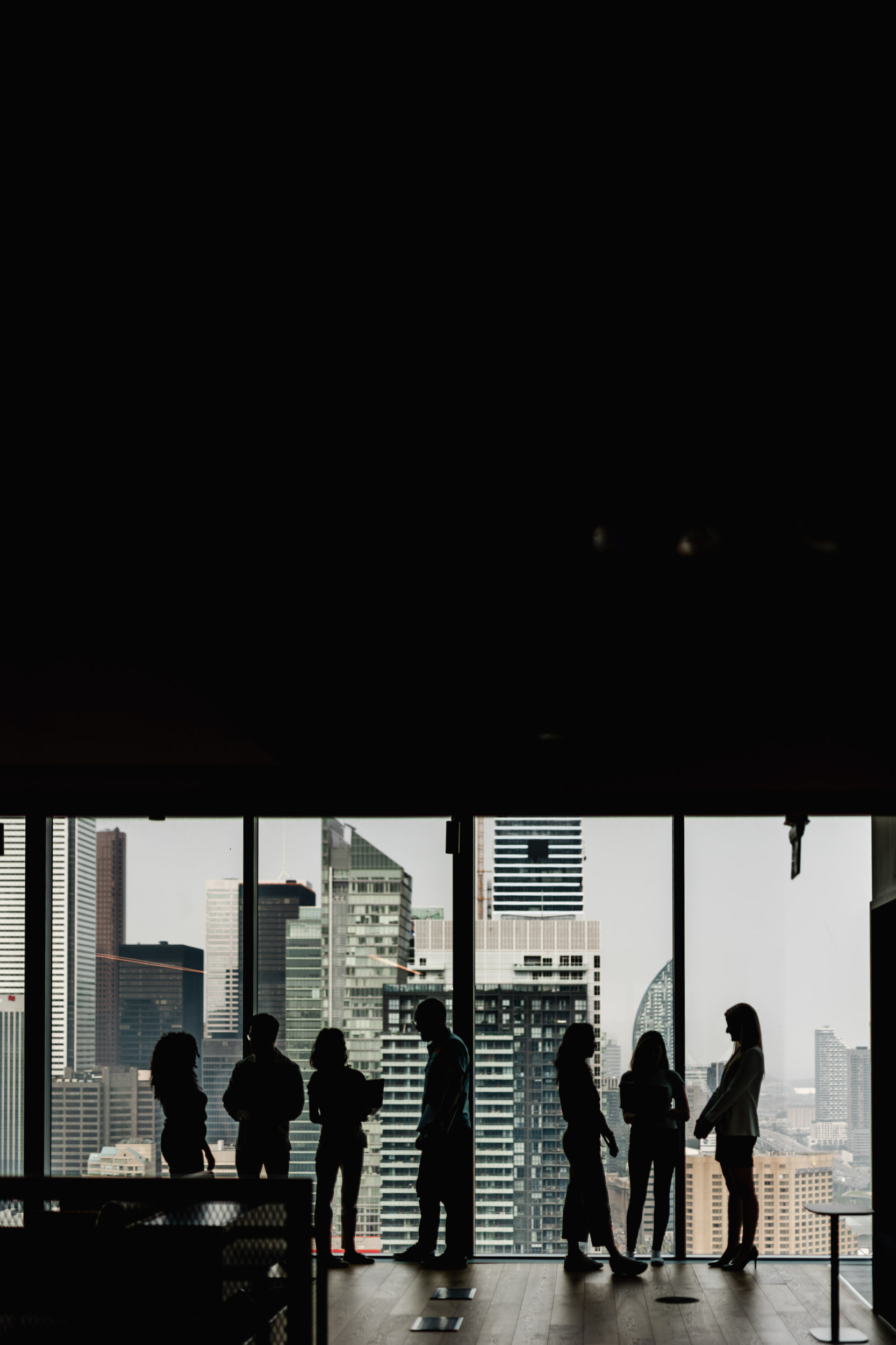 A group of people standing in front of a window overlooking the city view at Index Exchange headquarters.