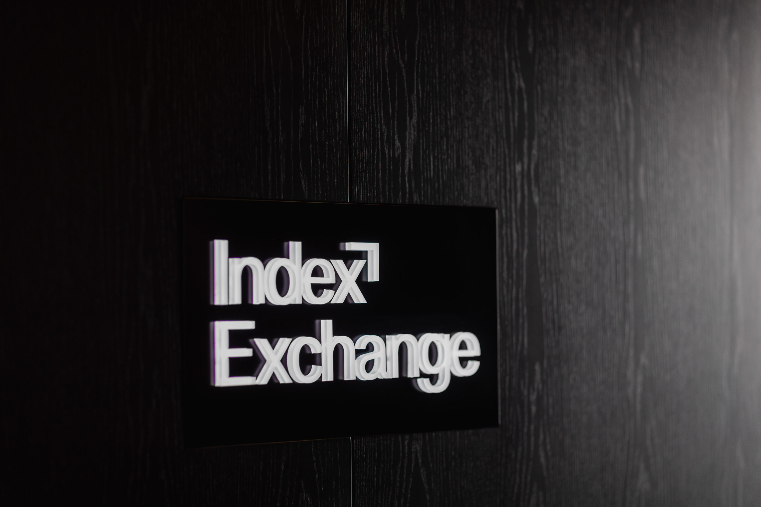 Index Exchange logo on black wall.