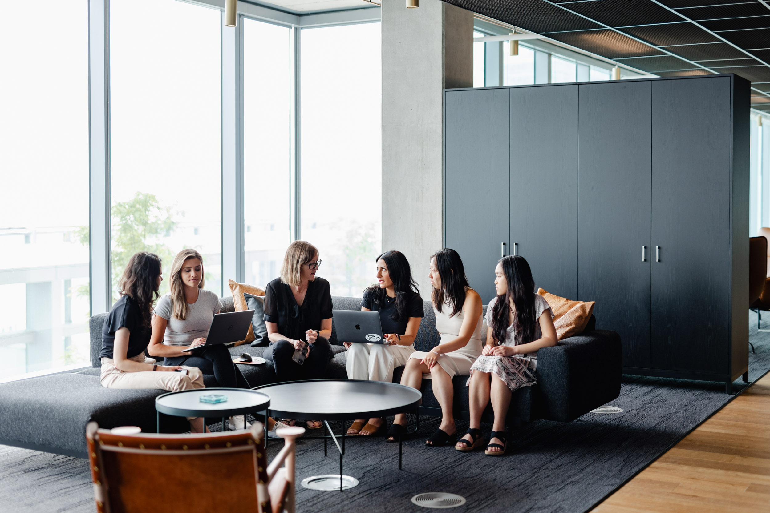 A group of women at Index Exchange sitting around a couch in an office.