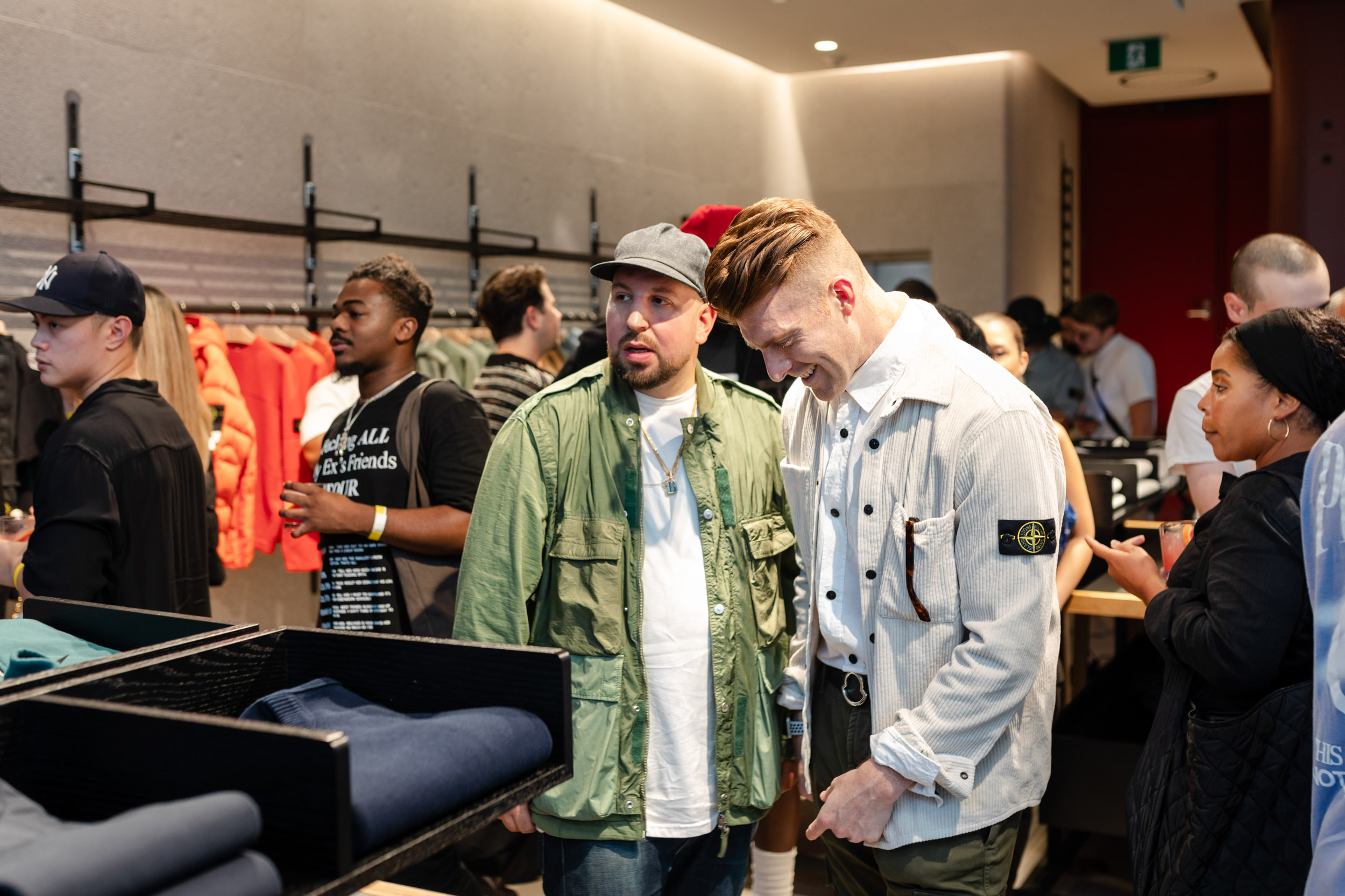 A group of people browsing clothes in Stone Island store