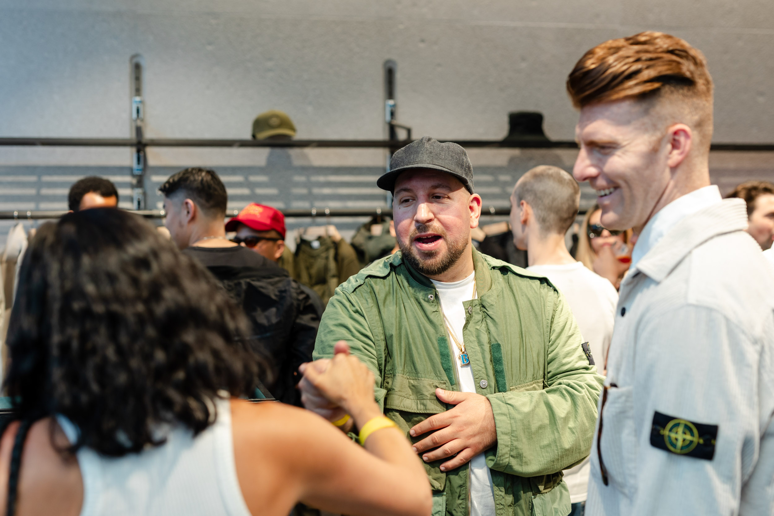A group of people engaging in conversation while shopping at the Stone Island Store