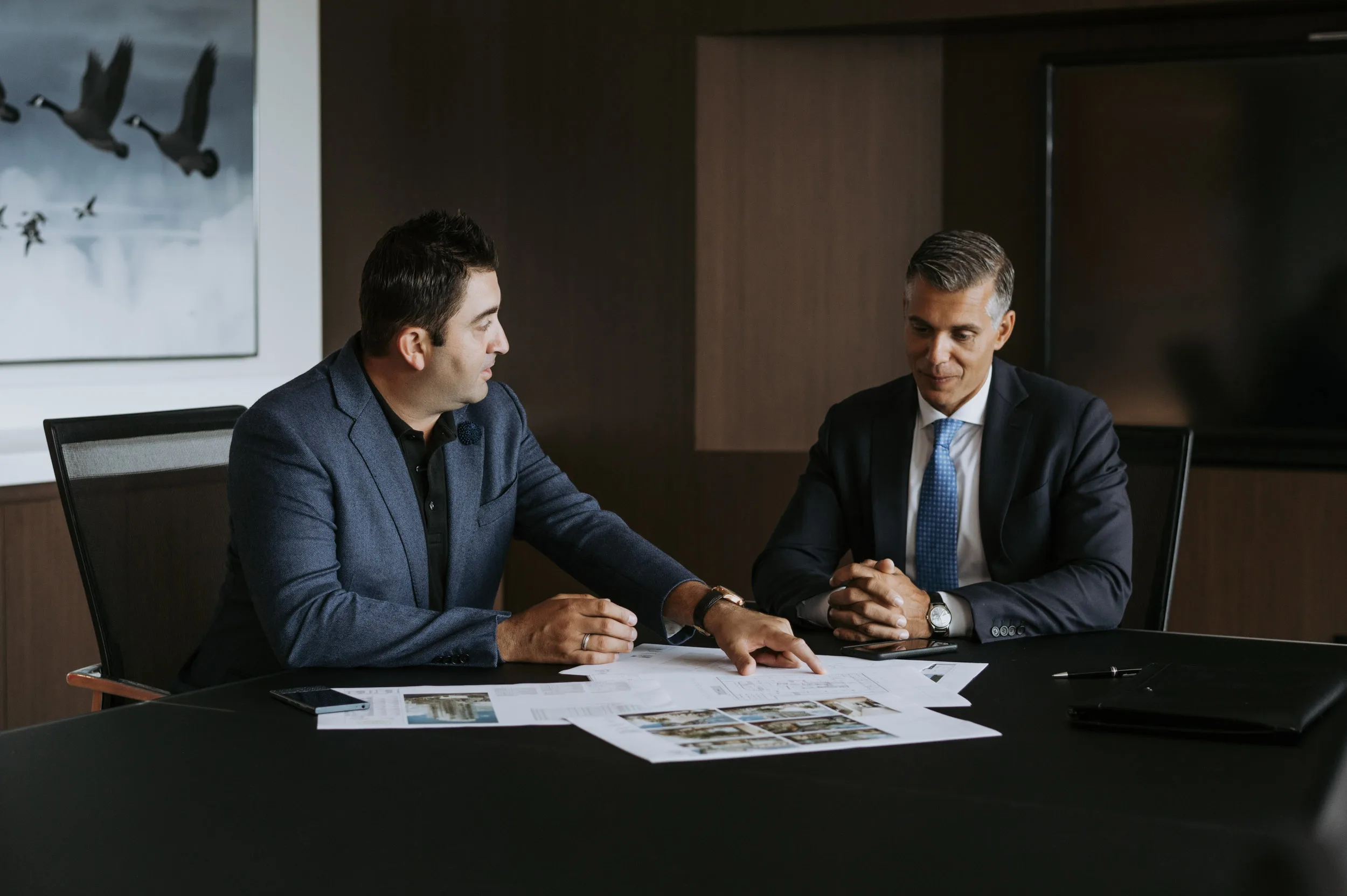 Two professionals sitting at a table during a formal meeting.