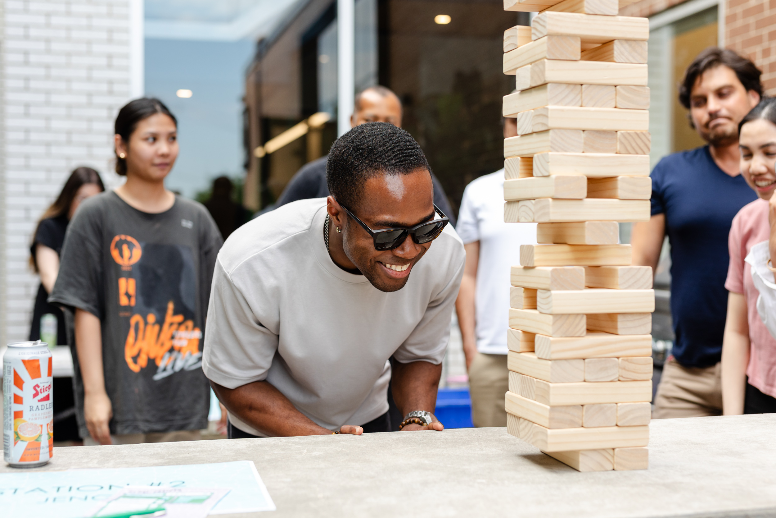 Social event involving people playing Jenga captured by photography.
