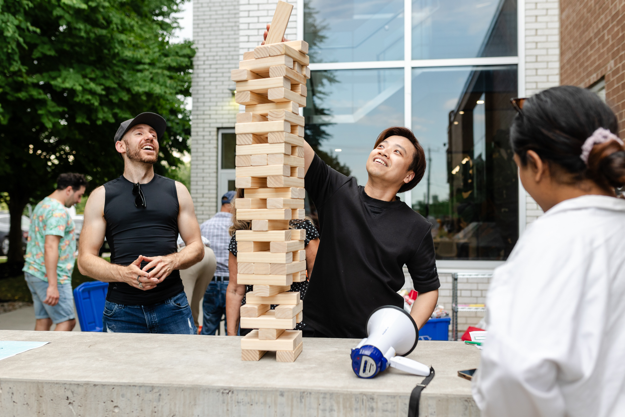 Social Event: A group of people playing a game of Jenga at a gathering.
