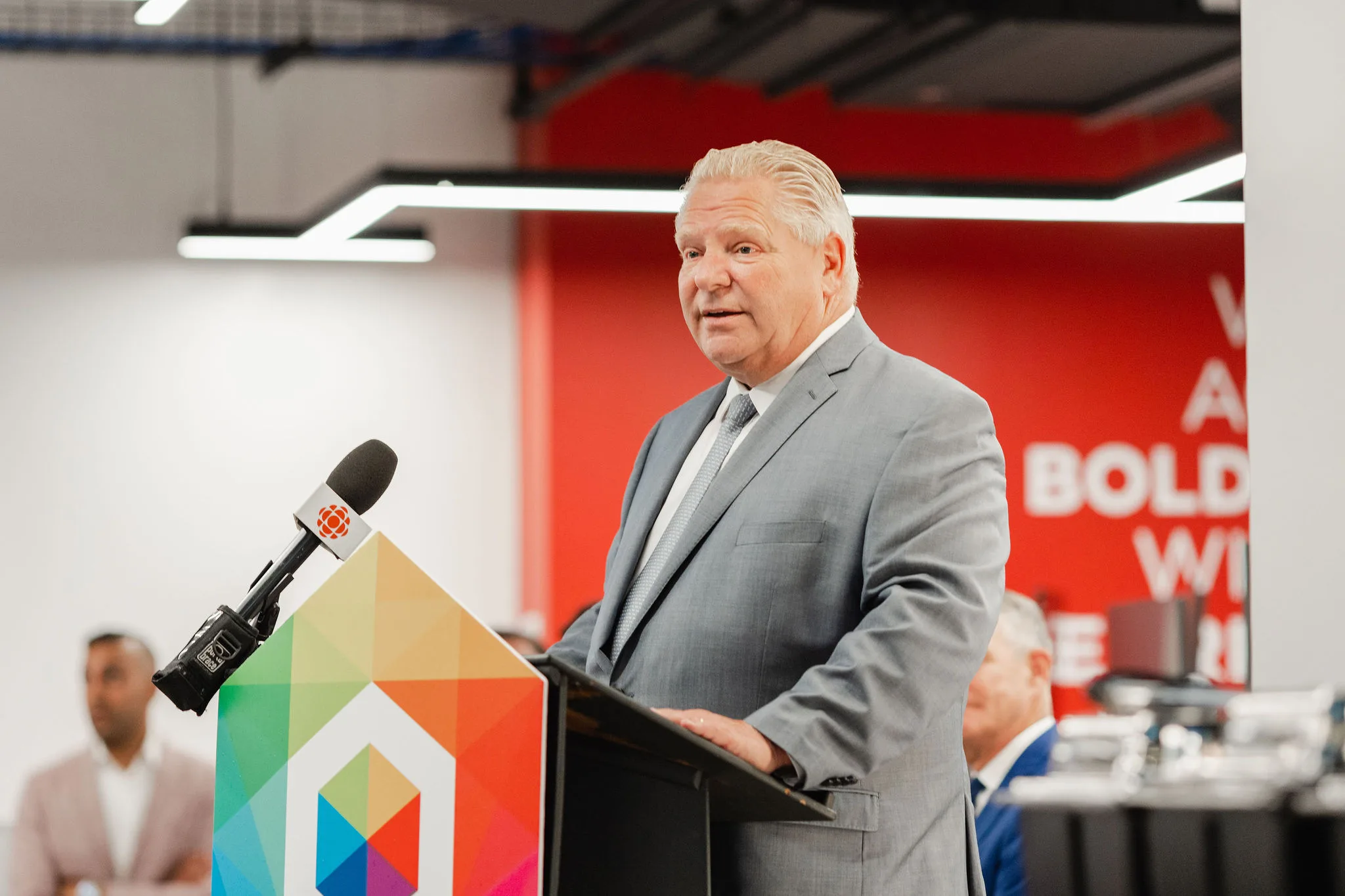 A man in a suit standing confidently at a podium.