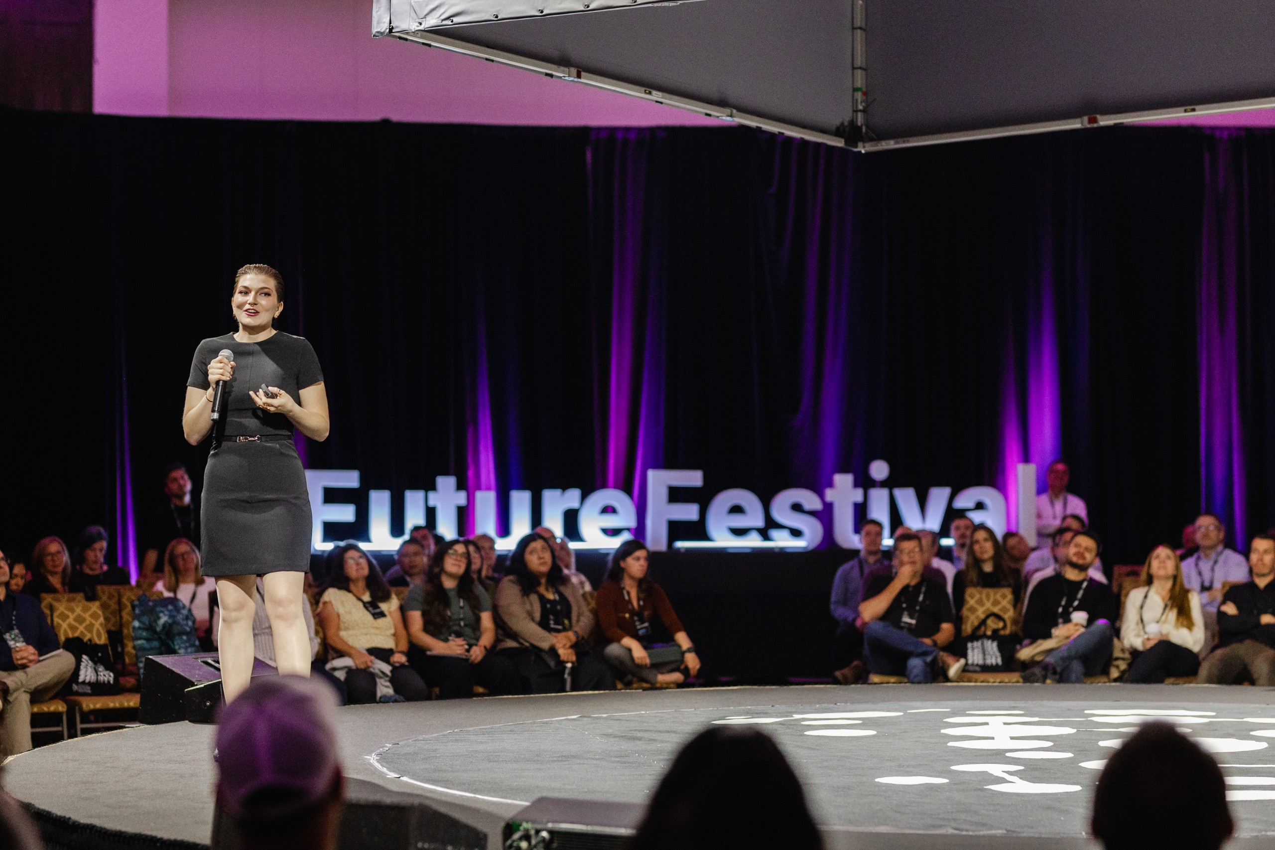 A woman delivering a captivating presentation at a vibrant future festival, captured through event photography.