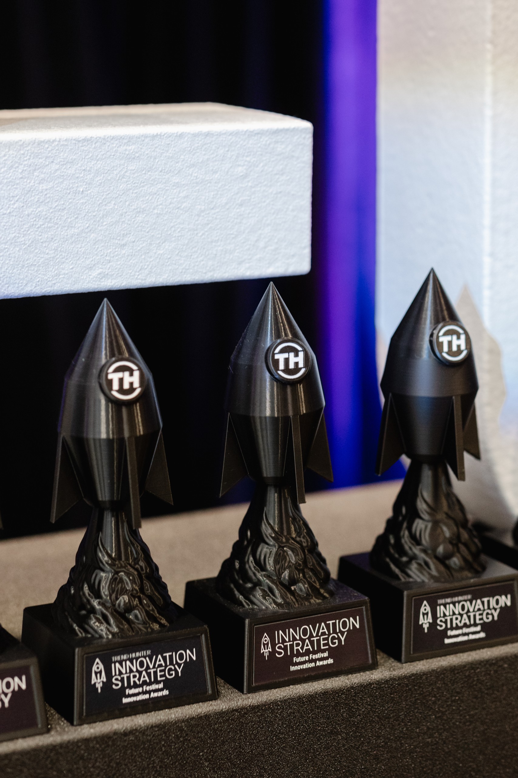 A group of black trophies from an event sitting on a table.