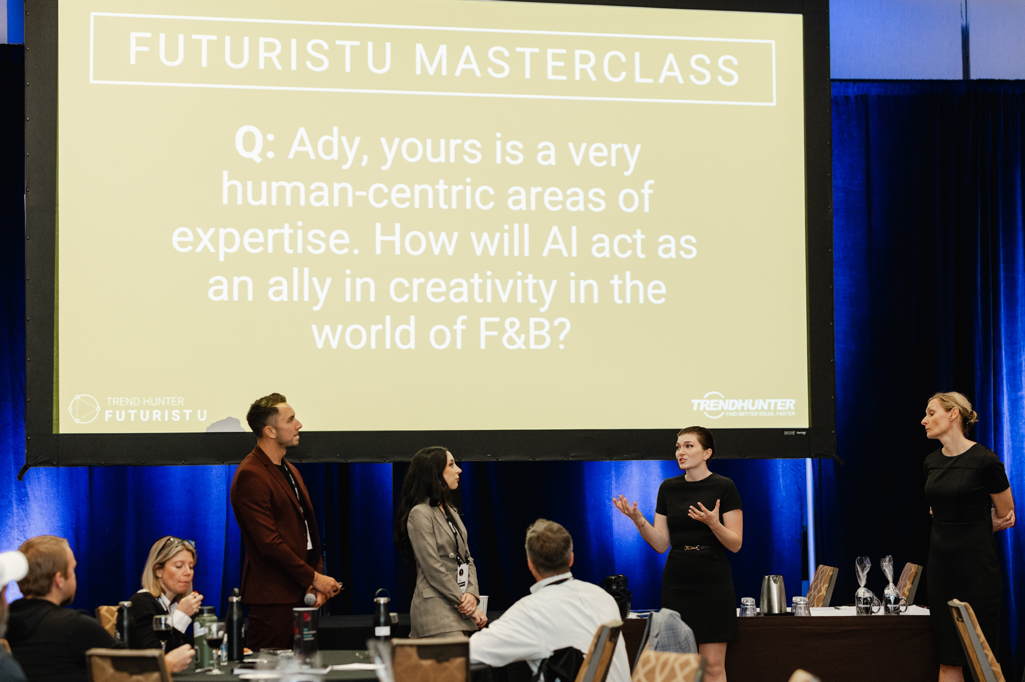 An event photography capture of a group of people standing in front of a screen displaying the words futurist masterclass.