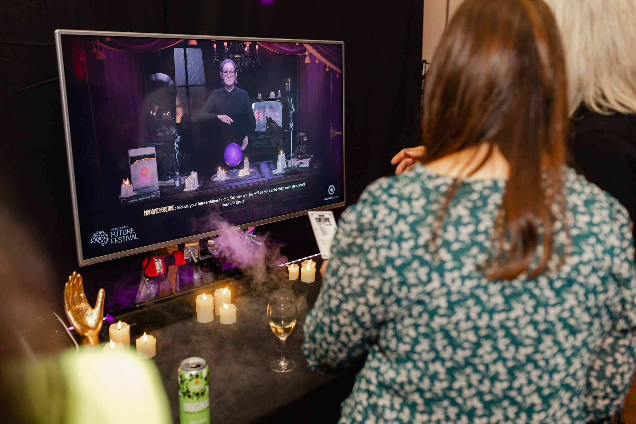Keywords: event photography

Description: An event photography capturing a group of people gathered around a TV in front of a cozy fireplace, engrossed in the on-screen content.