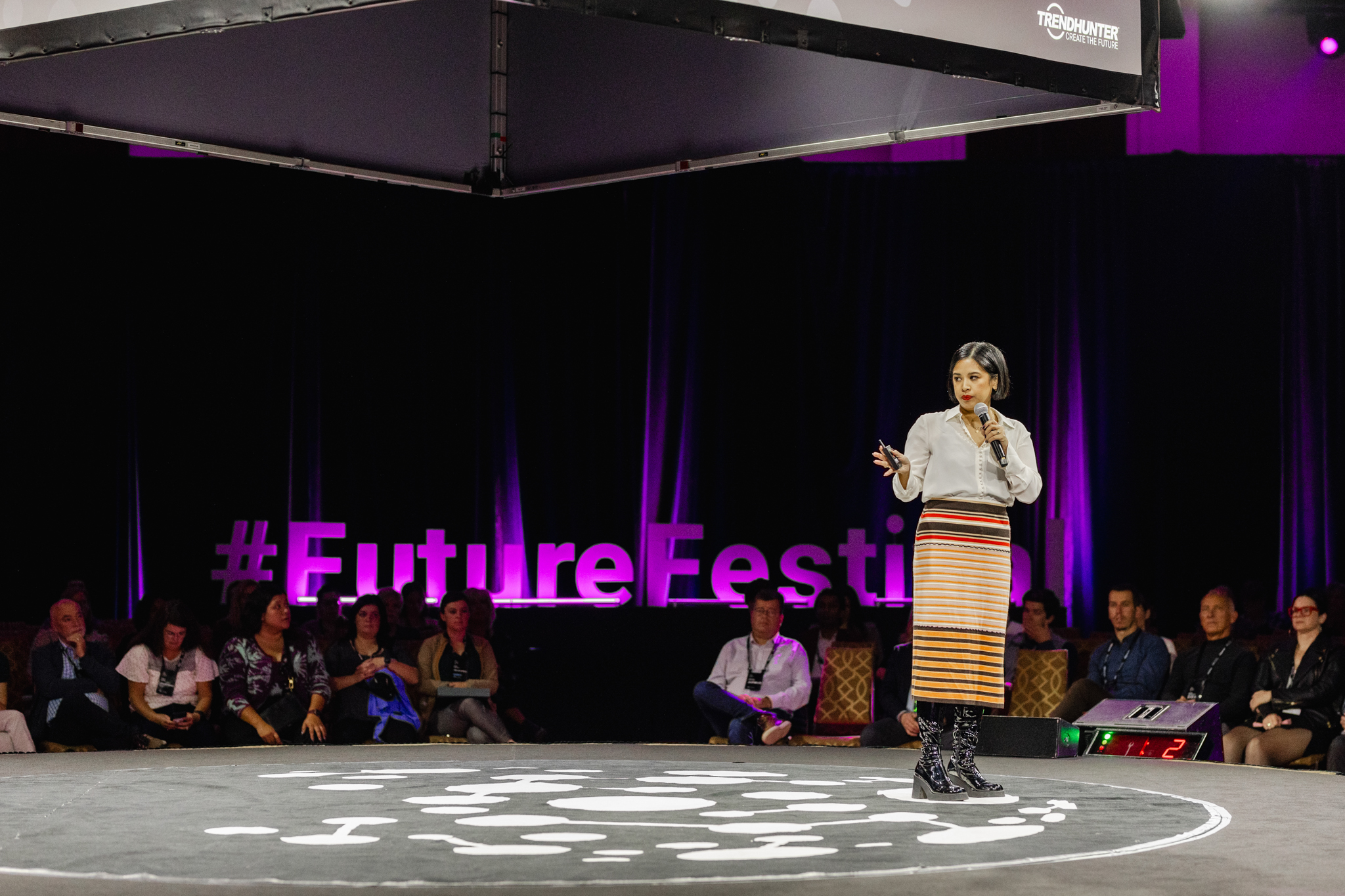 A woman speaking on stage at a future fest event, captured through event photography.