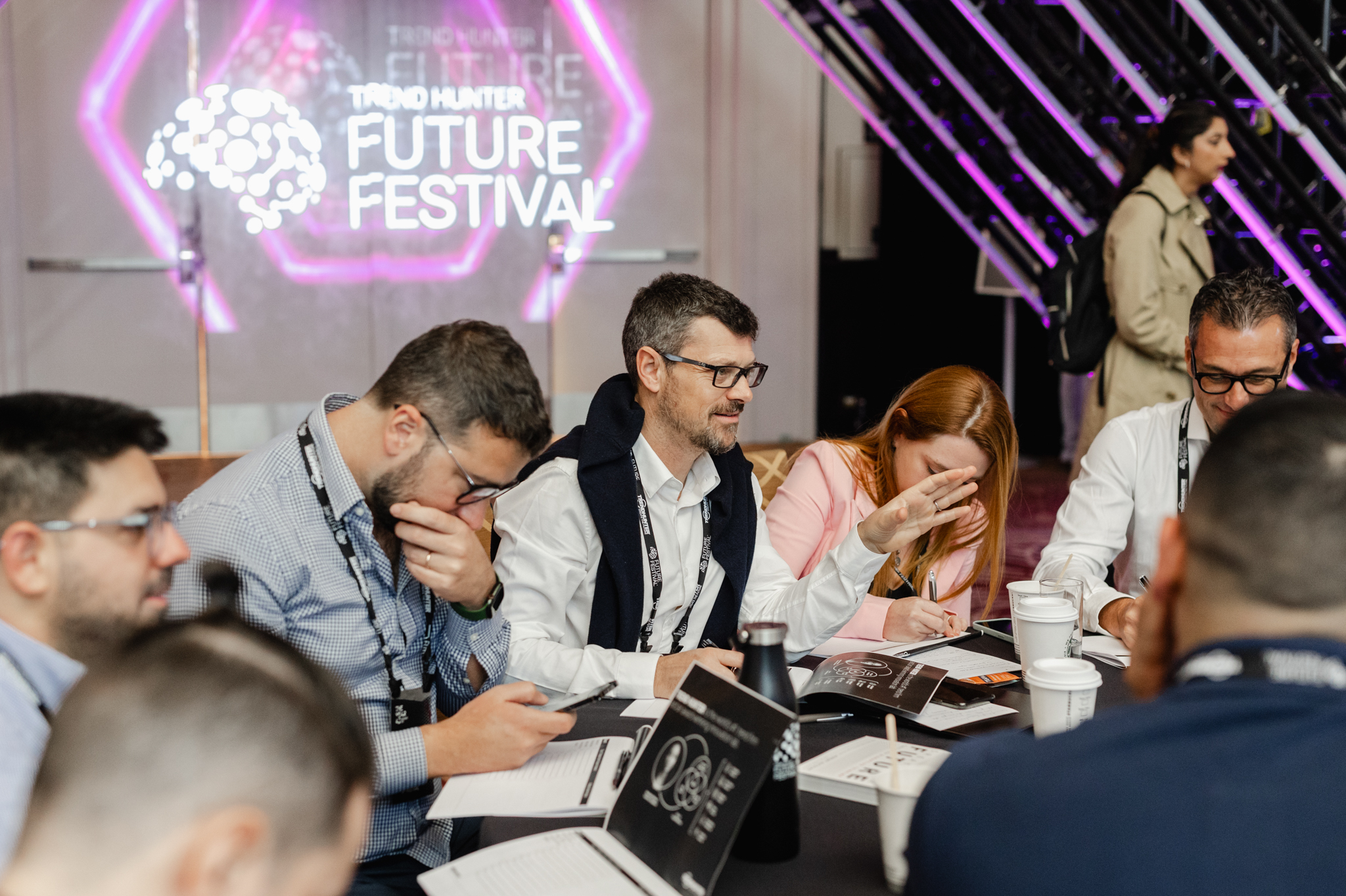 Event photography of a group of people sitting around a table at the future festival.
