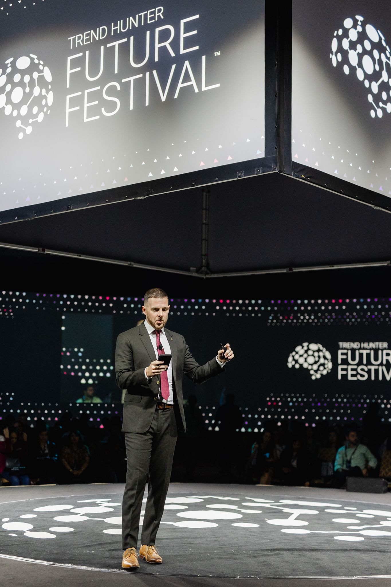 An event photographer capturing a man in a suit on stage at the future festival.