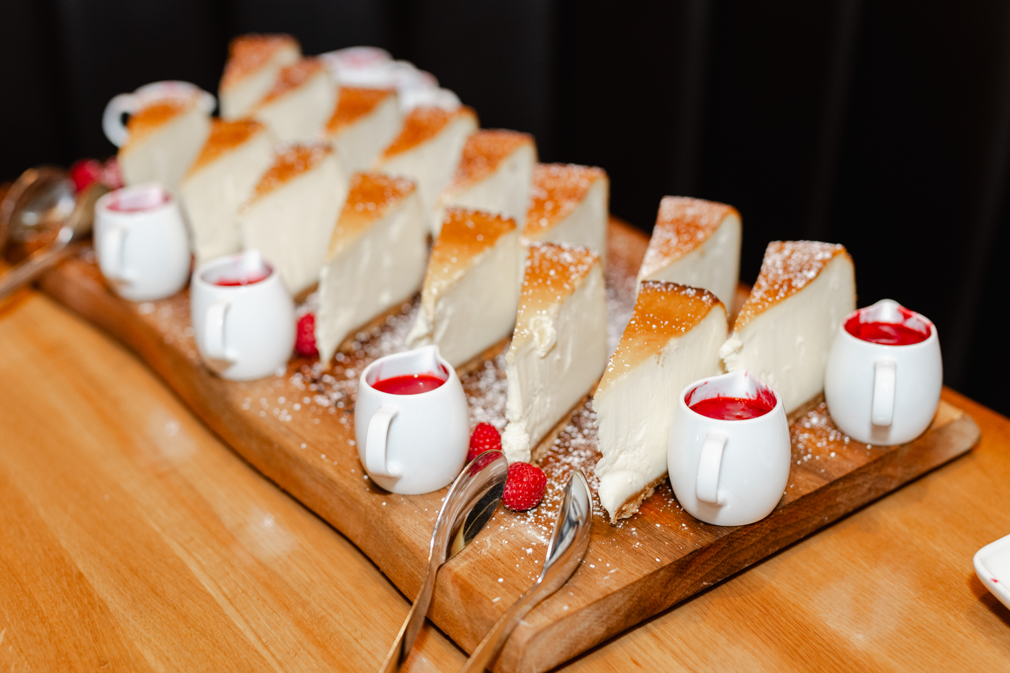 A stunning photograph capturing a delectable slice of cheesecake on a rustic wooden board, perfect for event photography.