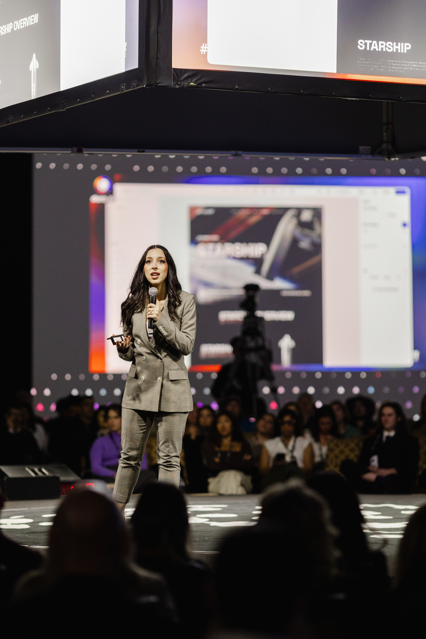 A woman giving a presentation on stage at an event. The moment is captured beautifully through event photography.