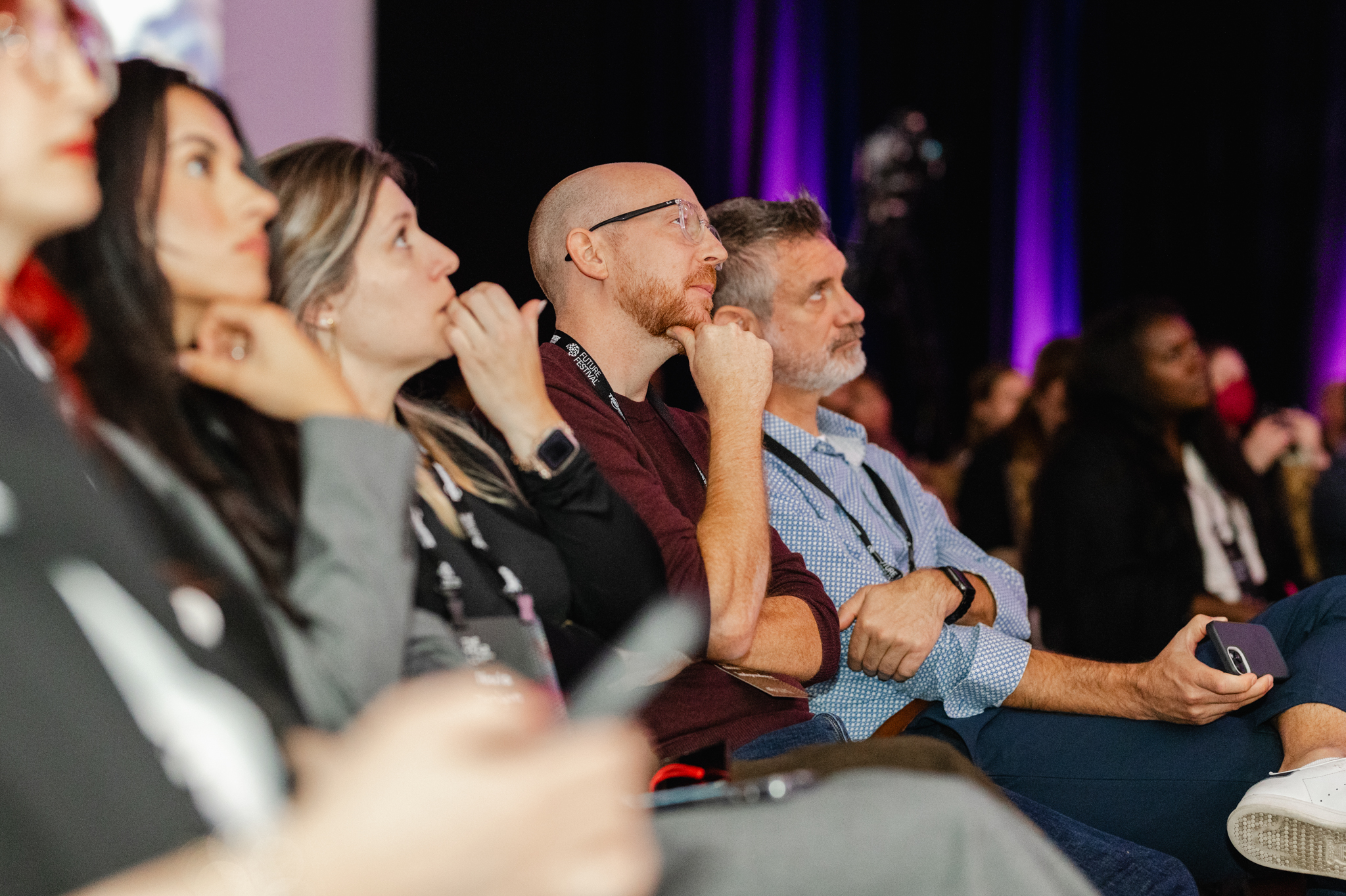 A group of people sitting in the audience at an event.