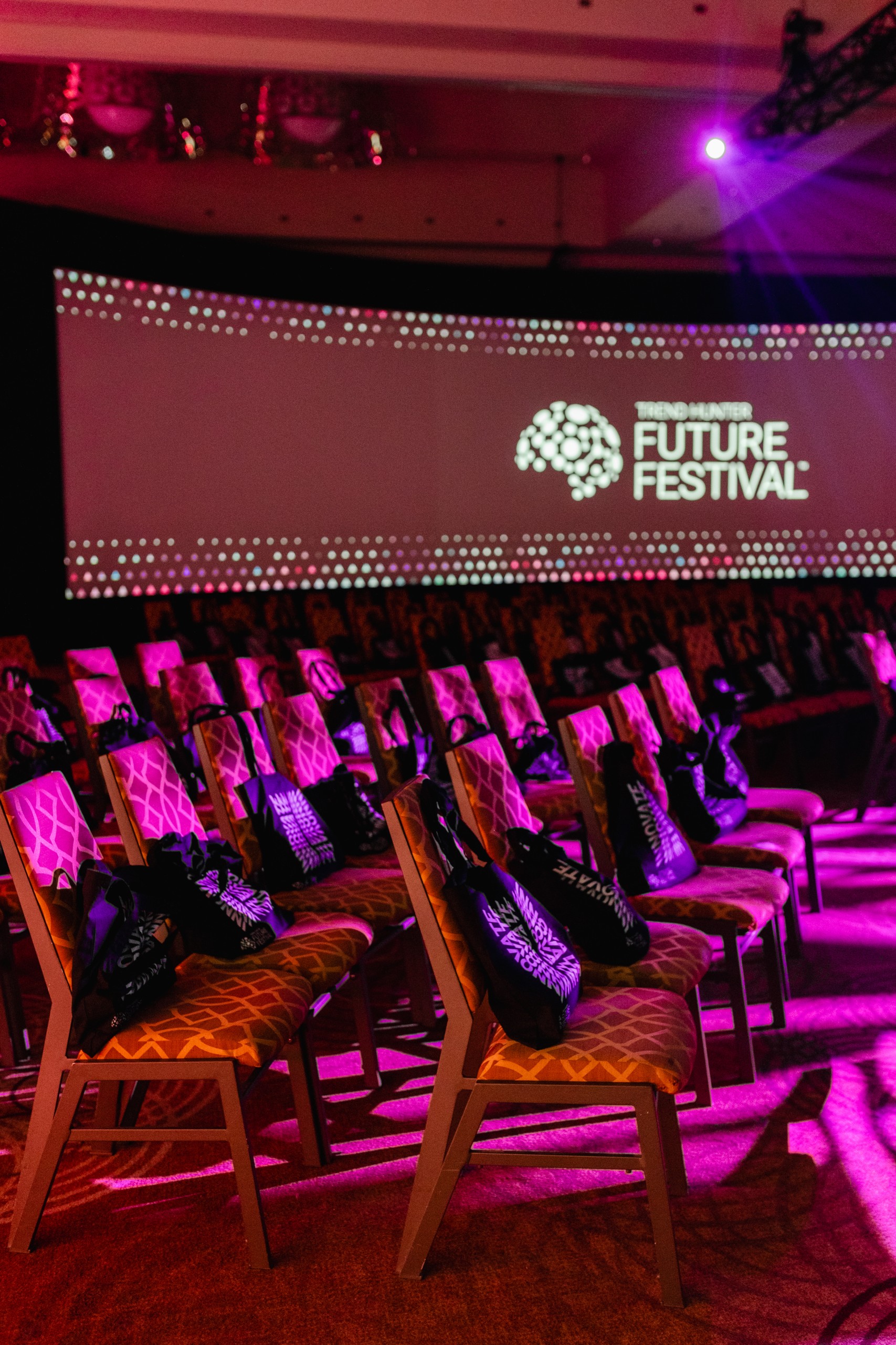 A room full of chairs and a screen displaying the word "future festival", capturing the essence through event photography.